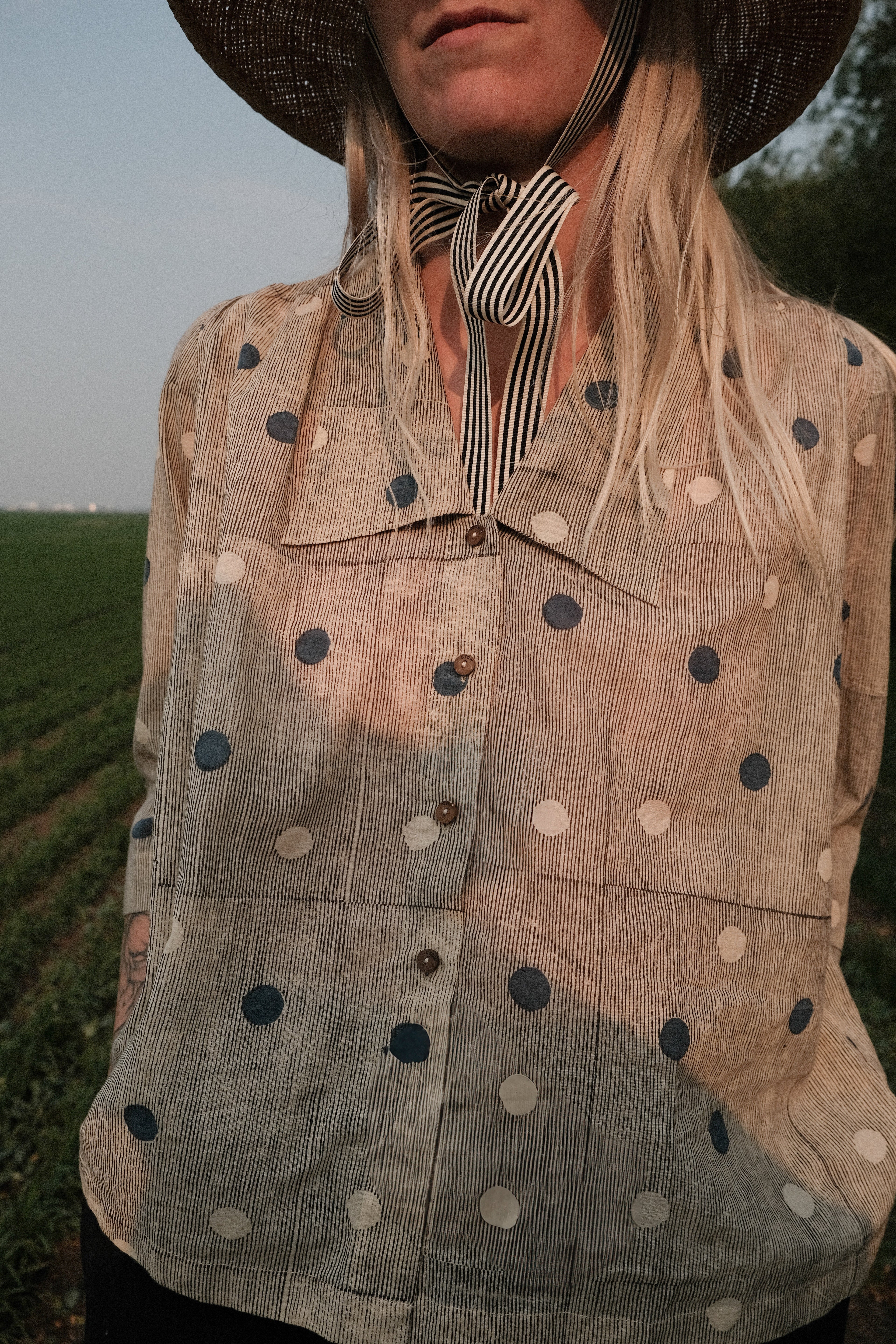 Black and tan hand block-printed top made from 100% organic cotton, featuring a front button opening and a relaxed silhouette. Naturally dyed and ethically crafted, the lightweight, non-stretchy fabric feels soft and breathable against the skin. Each piece is one-of-a-kind, with subtle variations in print and color that highlight its artisanal charm. Falls 25” from the shoulder and fits true to size—ideal for conscious, everyday wear.