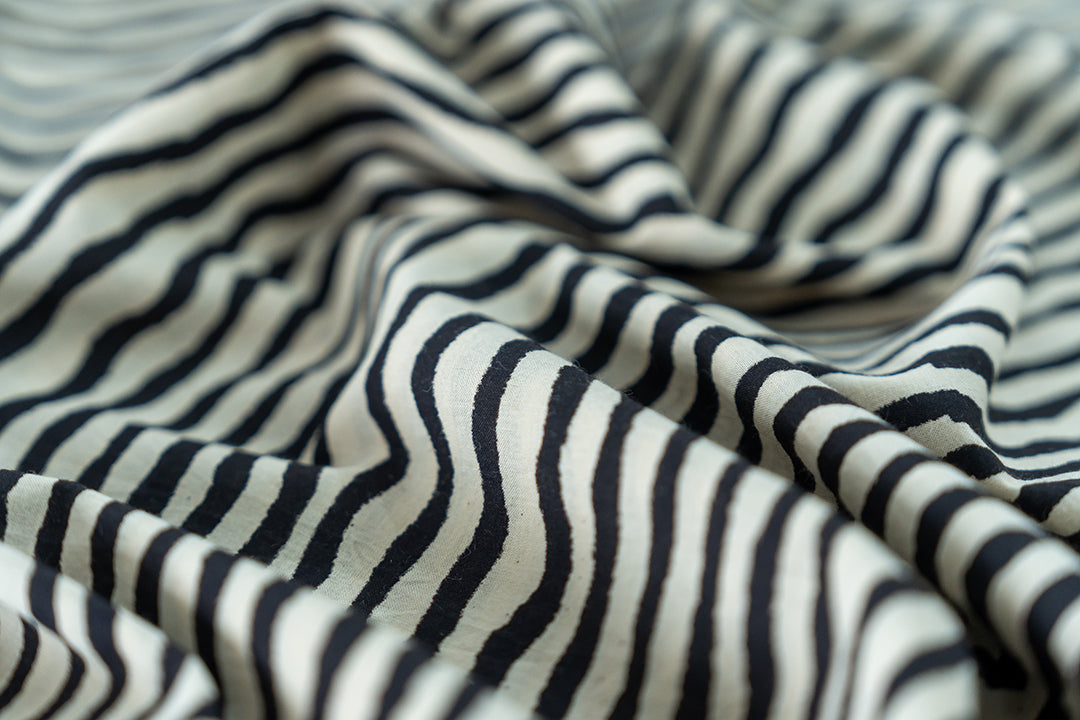 The fabric has hand-drawn like lines stripes in black & white colour.