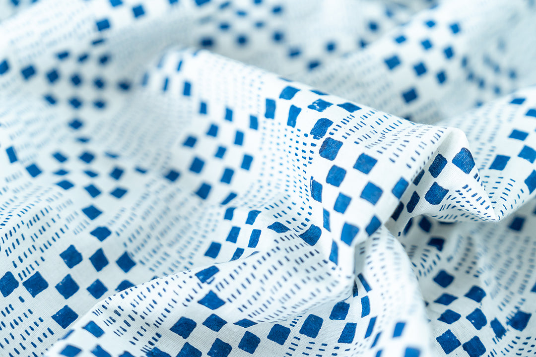 This detailed photo showcases an intricate indigo square pattern on a crisp white base.