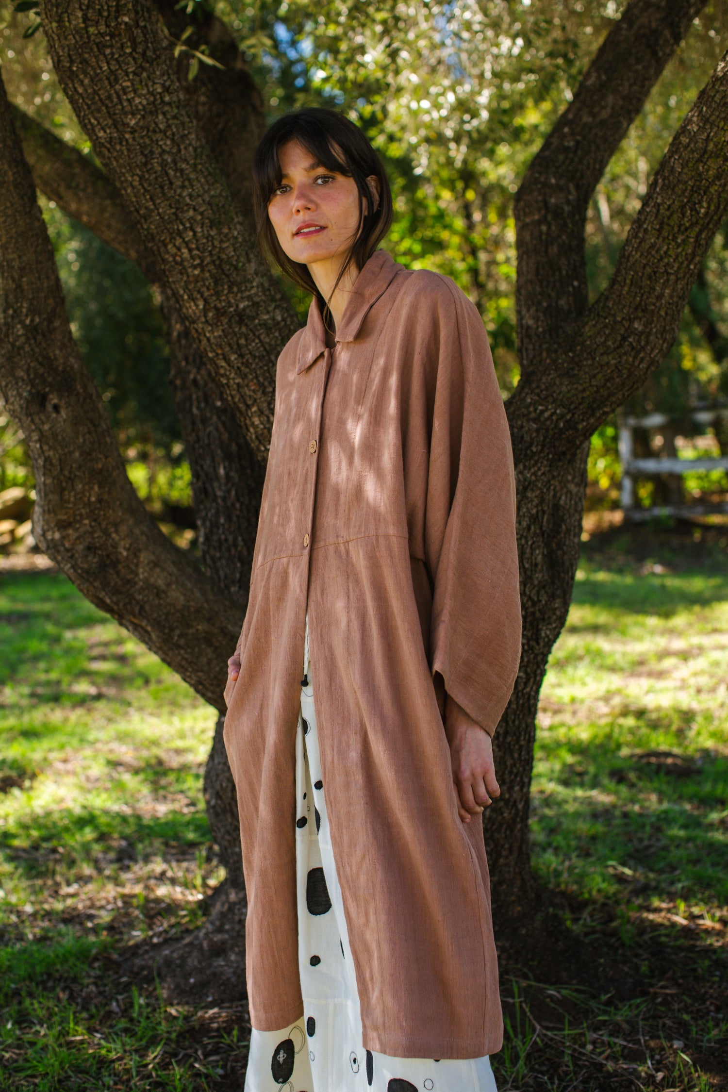 Introducing the Brown Duster jacket, a versatile essential crafted from organic cotton. Designed with a sleek straight collar and adorned with charming coconut buttons, this jacket exudes charm & sophistication. With its straight hem and relaxed fit, it offers both comfort and effortless elegance for any occasion.