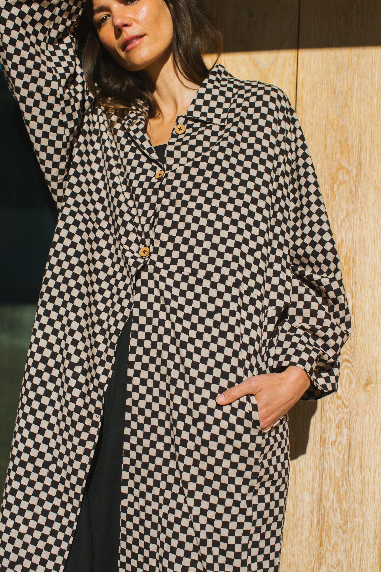 Elevate your style with this eye-catching red duster jacket, adorned with coconut buttons for a touch of natural charm. Crafted from high-quality block print fabric, this jacket boasts a timeless black and white checkered pattern, adding sophistication to any ensemble