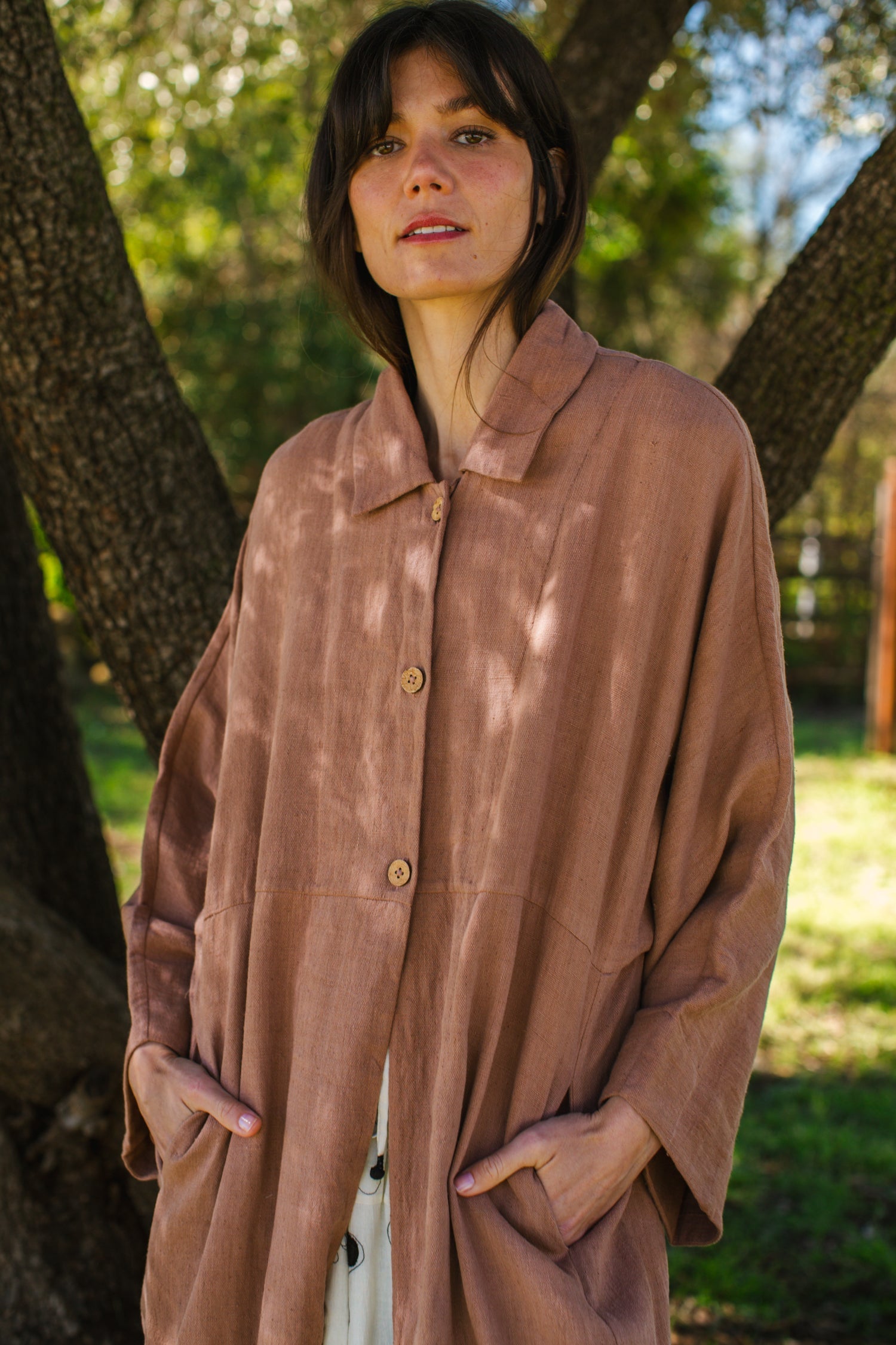 Introducing the Brown Duster jacket, a versatile essential crafted from organic cotton. Designed with a sleek straight collar and adorned with charming coconut buttons, this jacket exudes charm & sophistication. With its straight hem and relaxed fit, it offers both comfort and effortless elegance for any occasion.