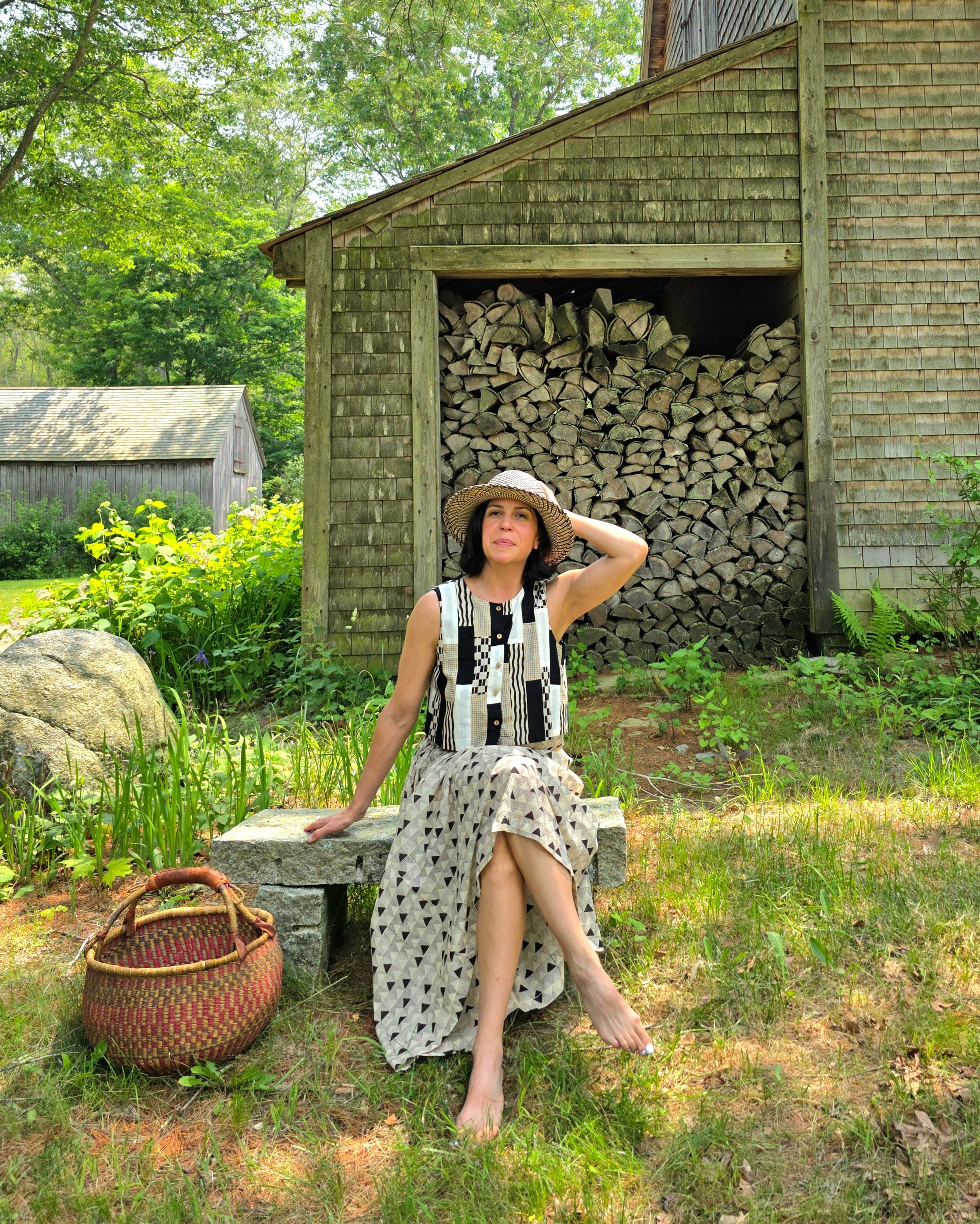 A mid-length, handwoven skirt made from soft, breathable organic cotton. The fabric features a delicate, all-over triangular block print in muted tones of black and grey on an off-white base. Lightly gathered at the waist, the skirt flows into a relaxed, voluminous silhouette that offers both comfort and movement. Naturally dyed and finished with a subtle texture, the skirt has an earthy, artisanal feel ideal for everyday wear.