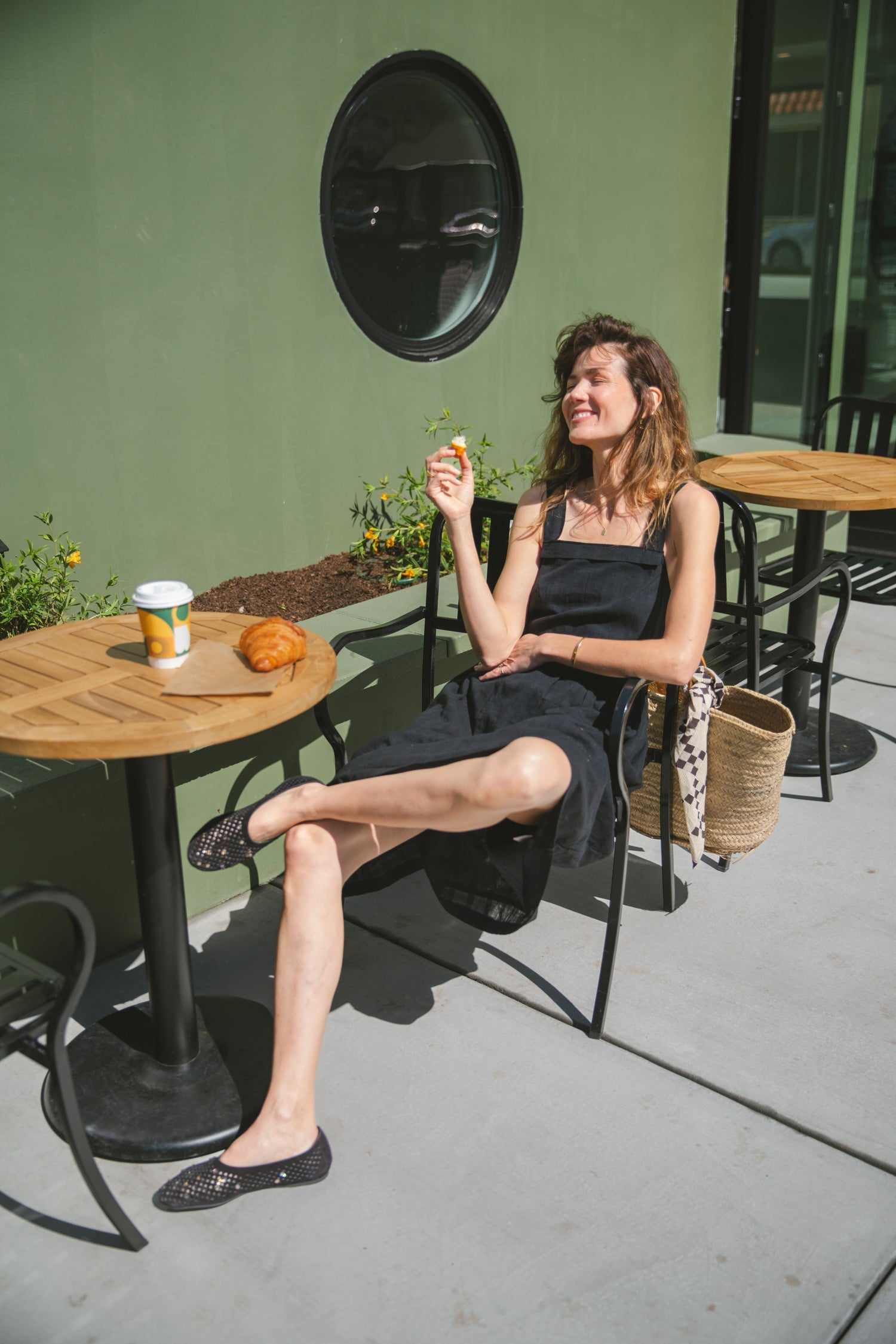 This is a black sleeveless midi dress with a structured square neckline and wide shoulder straps. The dress features a loose, flowing silhouette with a gathered waistline that adds volume and movement. Crafted from a lightweight, breathable fabric, it drapes effortlessly, making it perfect for warm weather. Functional side pockets enhance its practicality, while the relaxed fit exudes a laid-back yet refined charm. The minimalist design and deep black hue create a versatile piece that can be styled casually