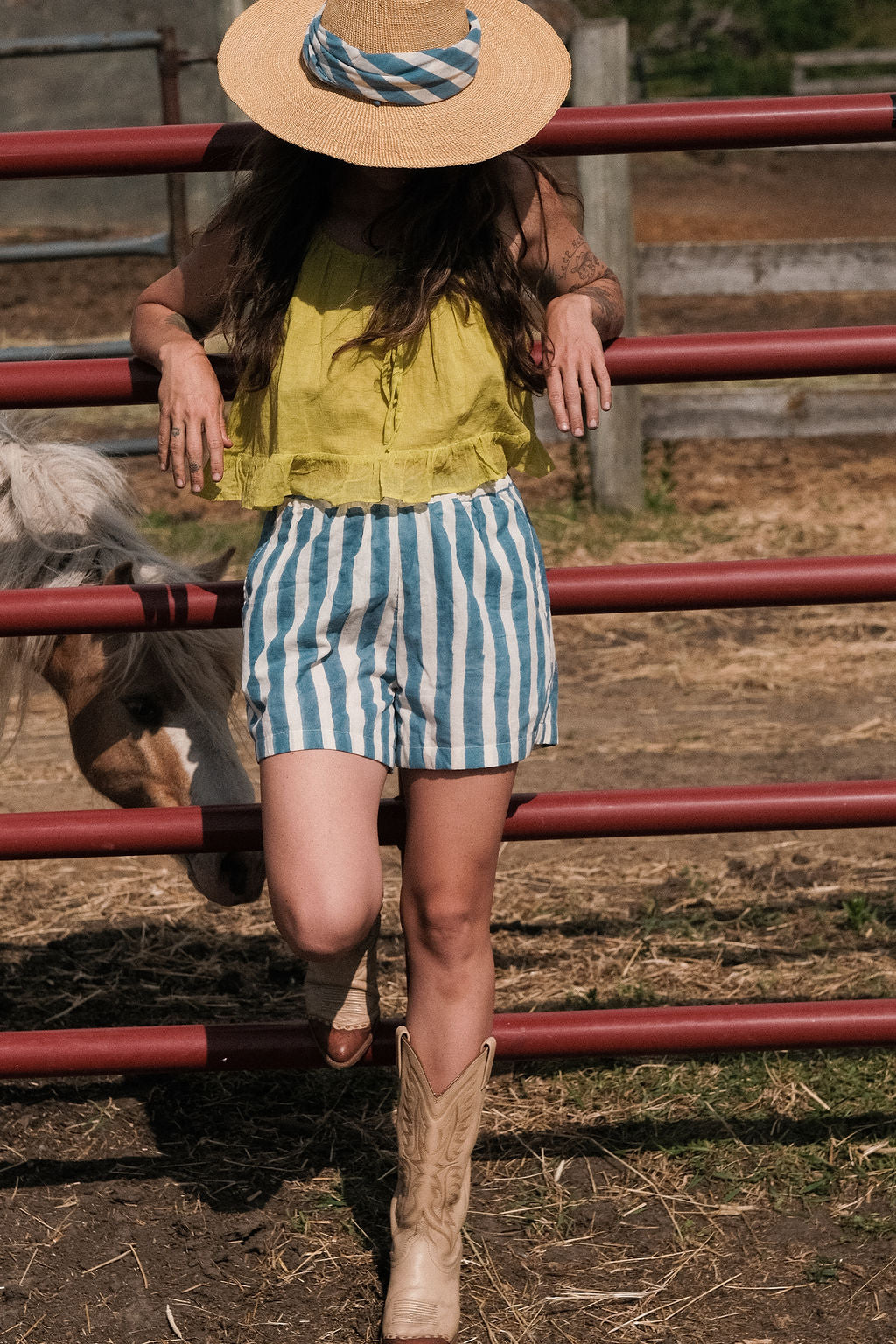 A sleeveless lime green top crafted from soft, handwoven organic cotton with a naturally crinkled texture. The fabric is naturally dyed using plant-based pigments, giving the lime tone a warm, earthy vibrance with subtle tonal variations. It features a gathered neckline with a fine tie detail at the front and a softly flared, cropped hem that creates an airy, relaxed silhouette ideal for summer.