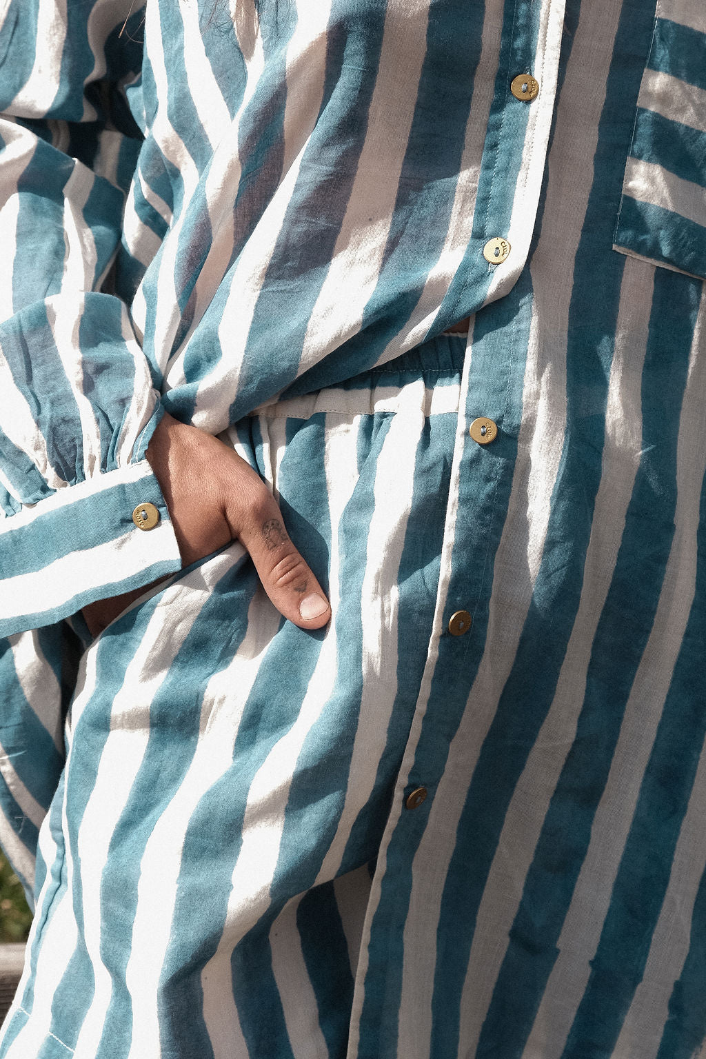 This summer blue artist smock has vertical blue and white stripes, classic collar, and a chest pocket with contrasting horizontal stripes. Made with soft cotton fabric and natural color.  The coconut buttons add the charm to the shirt and ensure an easy enclosure.