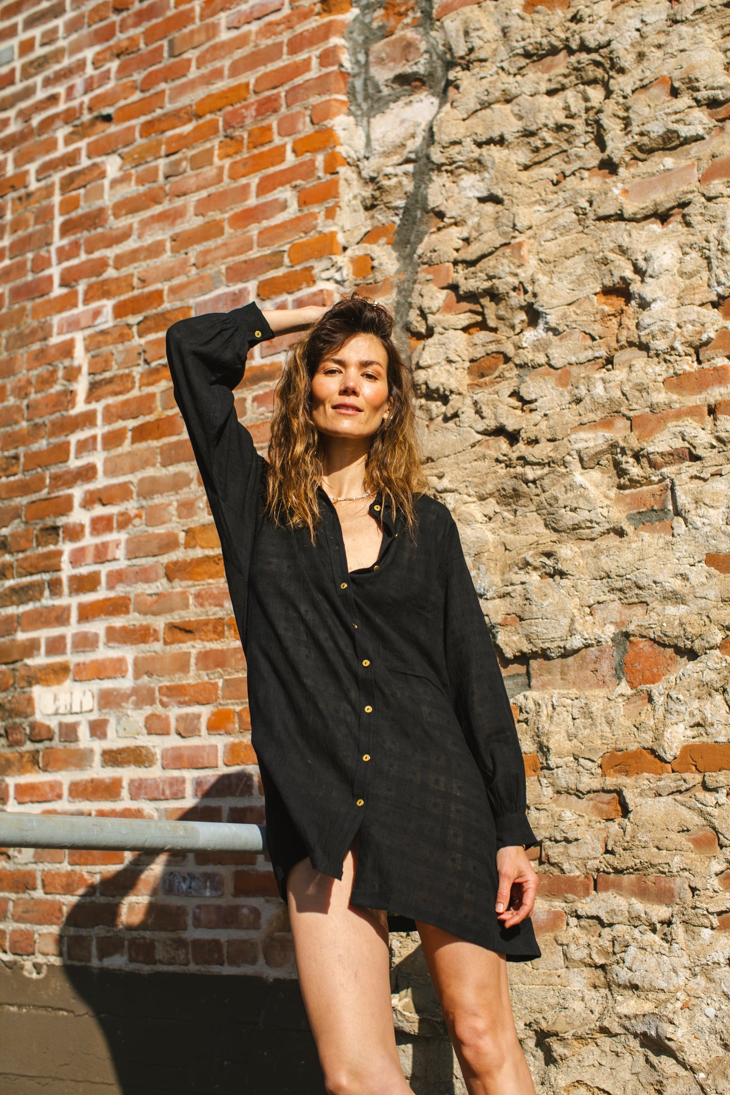 Black artist smock with a relaxed, oversized fit, featuring a button-down front, billowy long sleeves with gathered cuffs, and a subtle textured fabric. The lightweight, breathable material drapes effortlessly, creating a casual yet artistic look.