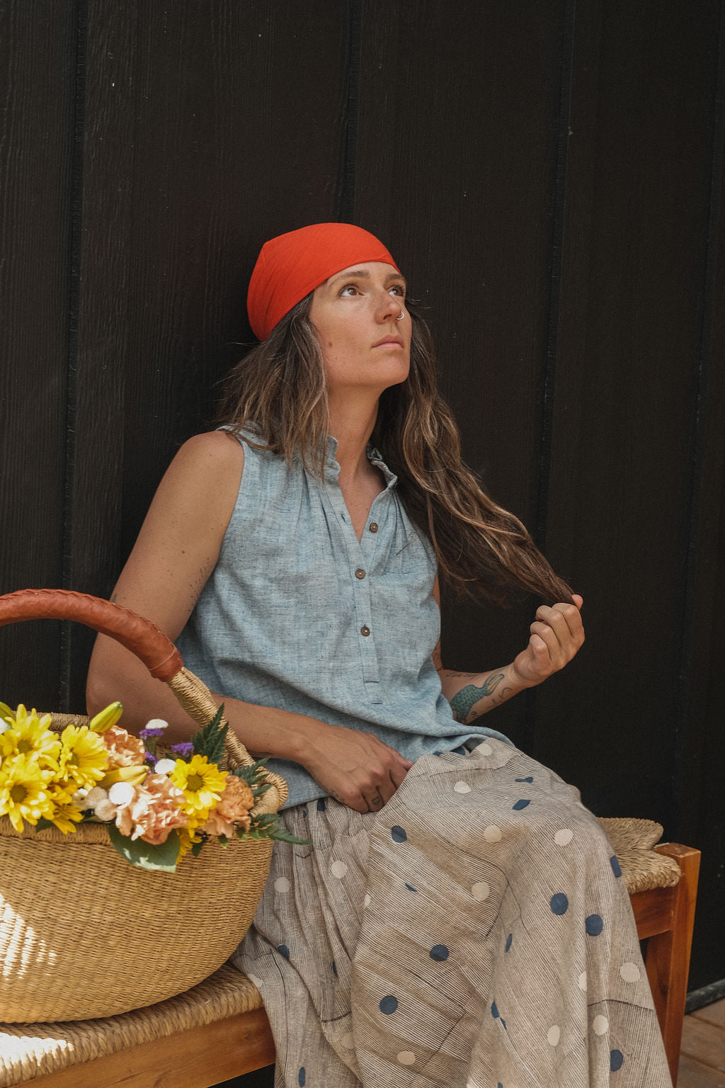 Sleeveless chambray blue top made from soft, handwoven organic cotton. Features a short button placket at the front and a subtle pleat detail below the collar, creating a clean and structured look. The stand collar adds a modern touch, while the breathable, lightweight fabric ensures comfort in warmer weather. Naturally dyed and ethically crafted, this top is perfect for effortless, everyday wear.