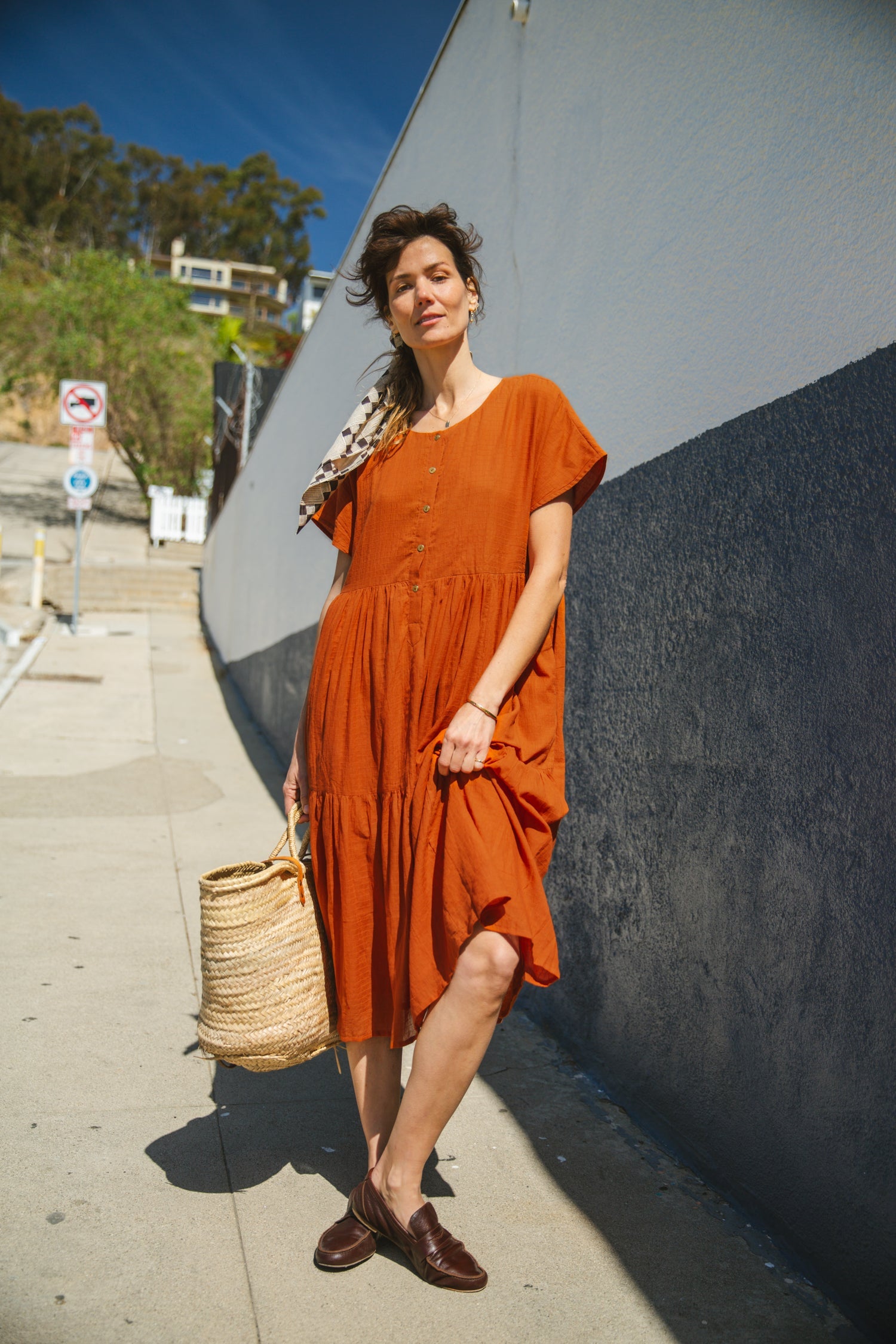 Rust orange tiered midi dress with a relaxed fit, short sleeves, a round neckline with a buttoned placket, and soft, lightweight fabric for an effortless, breezy style.