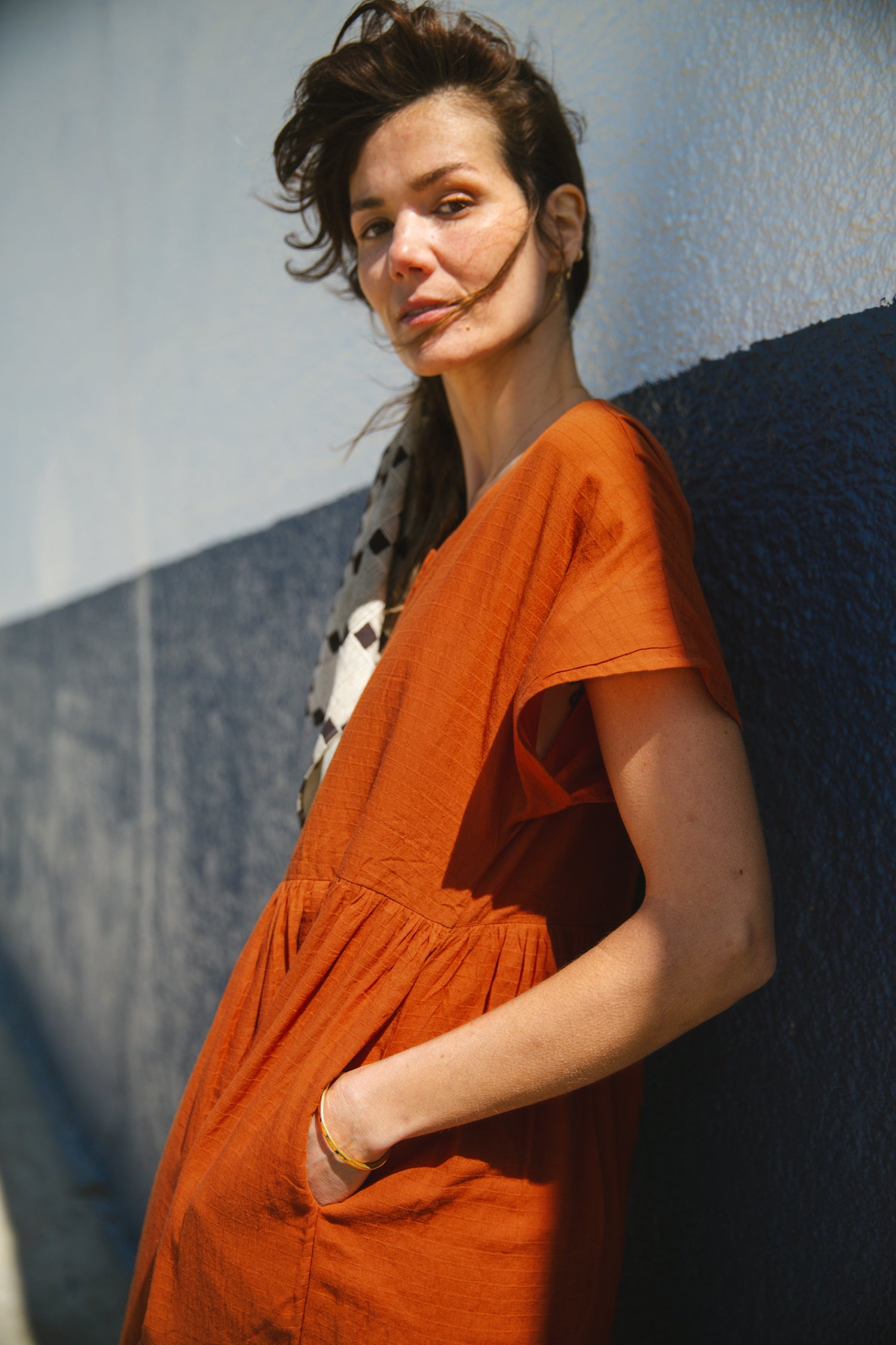 Rust orange tiered midi dress with a relaxed fit, short sleeves, a round neckline with a buttoned placket, and soft, lightweight fabric for an effortless, breezy style.