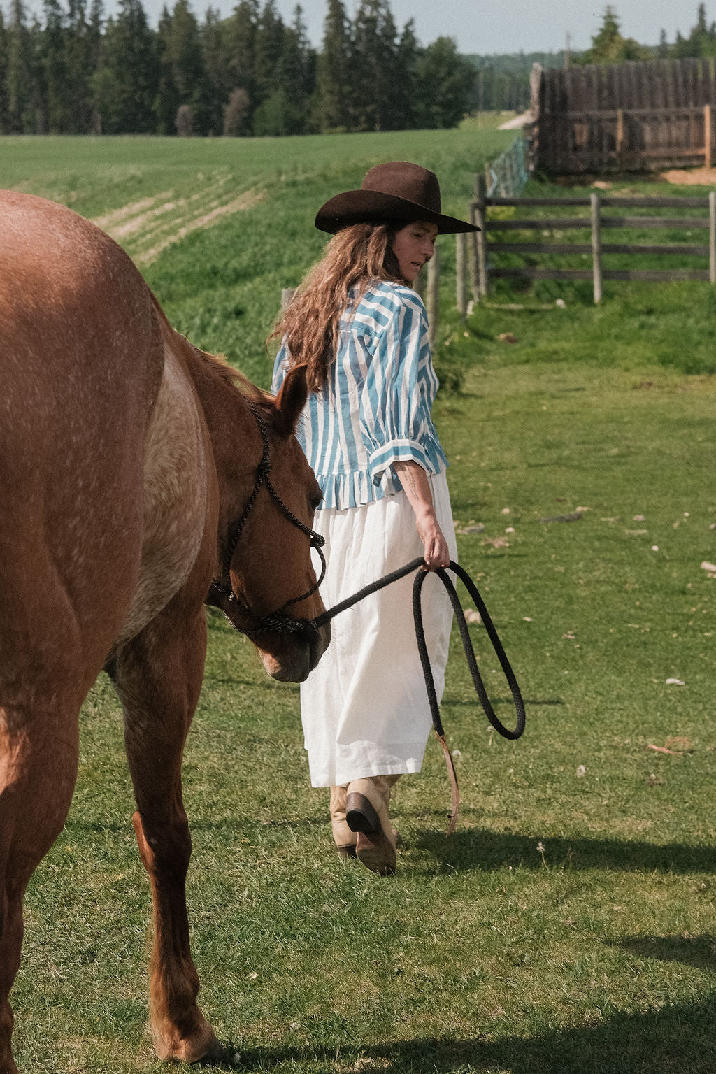 Handwoven blue and white striped cotton top featuring a V-neckline, button-down front, and gathered peplum hem. Made from breathable organic cotton with natural dyes, this lightweight blouse offers a relaxed fit with full sleeves—perfect for summer and resort wear.
