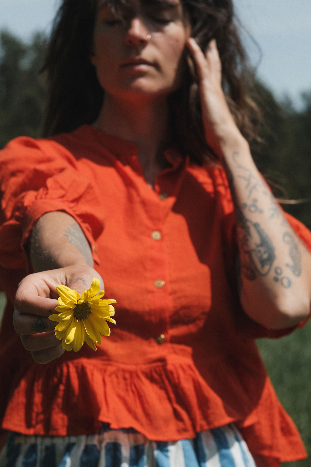 A vibrant red, cropped button-down top made from lightweight, handwoven organic cotton. The top features a relaxed fit with dropped shoulders and three-quarter sleeves, finished with a narrow cuff. The modern stan collar adds the charm to this lively top. The natural texture and breathable fabric give it an airy, effortless feel, ideal for warm-weather dressing.
