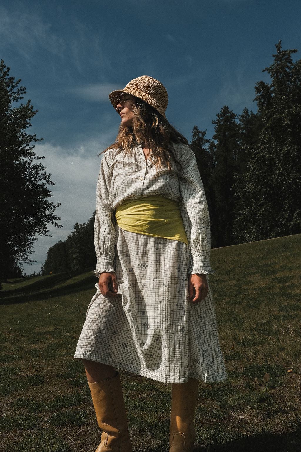 This Jamdani dress made with handwoven cotton is a perfect summer dress with its light color detailed square black threads. It has long sleeves with ruffles along a ruffled neck, and a midi length.