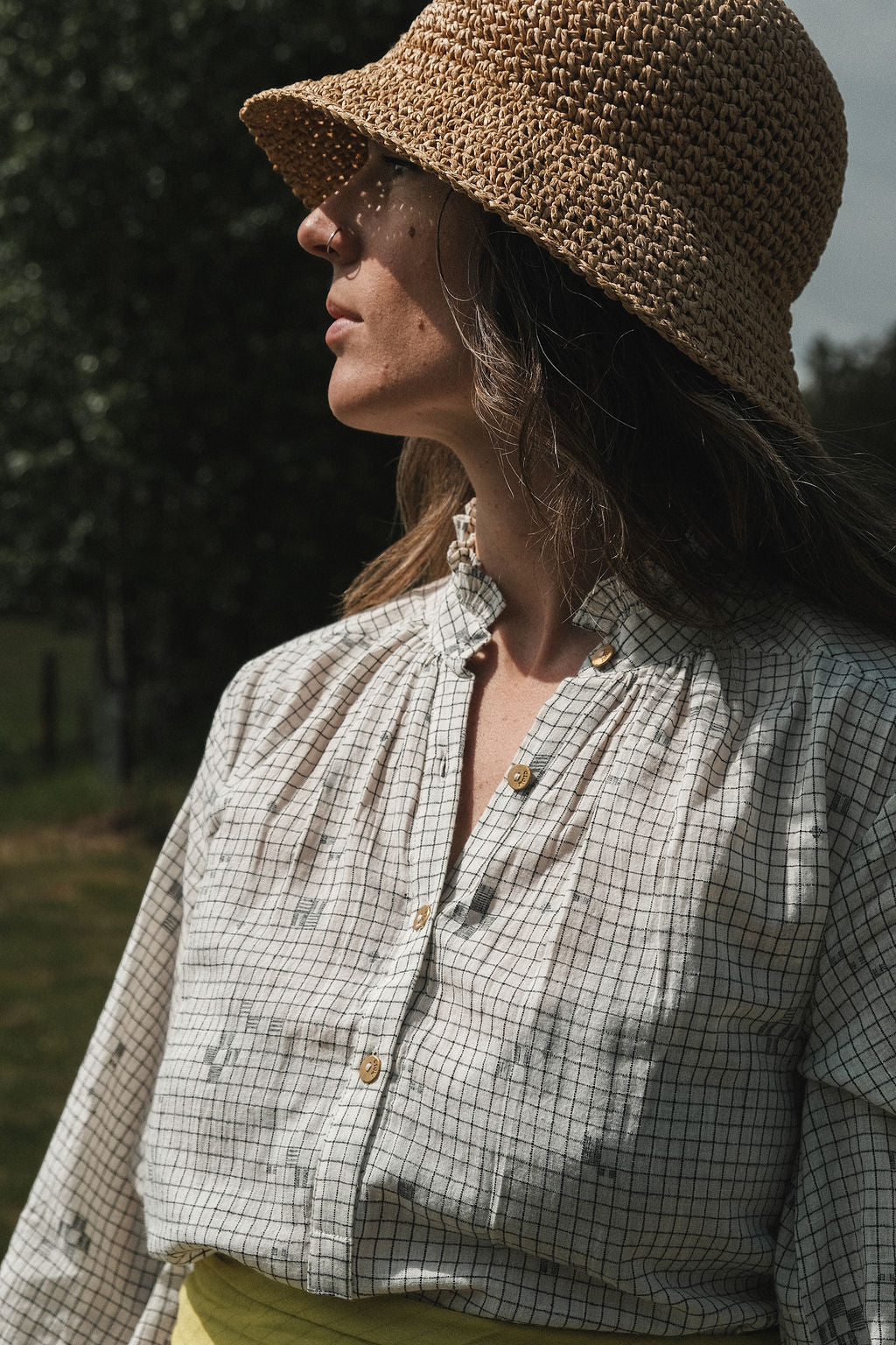 This Jamdani dress made with handwoven cotton is a perfect summer dress with its light color detailed square black threads. It has long sleeves with ruffles along a ruffled neck, and a midi length.