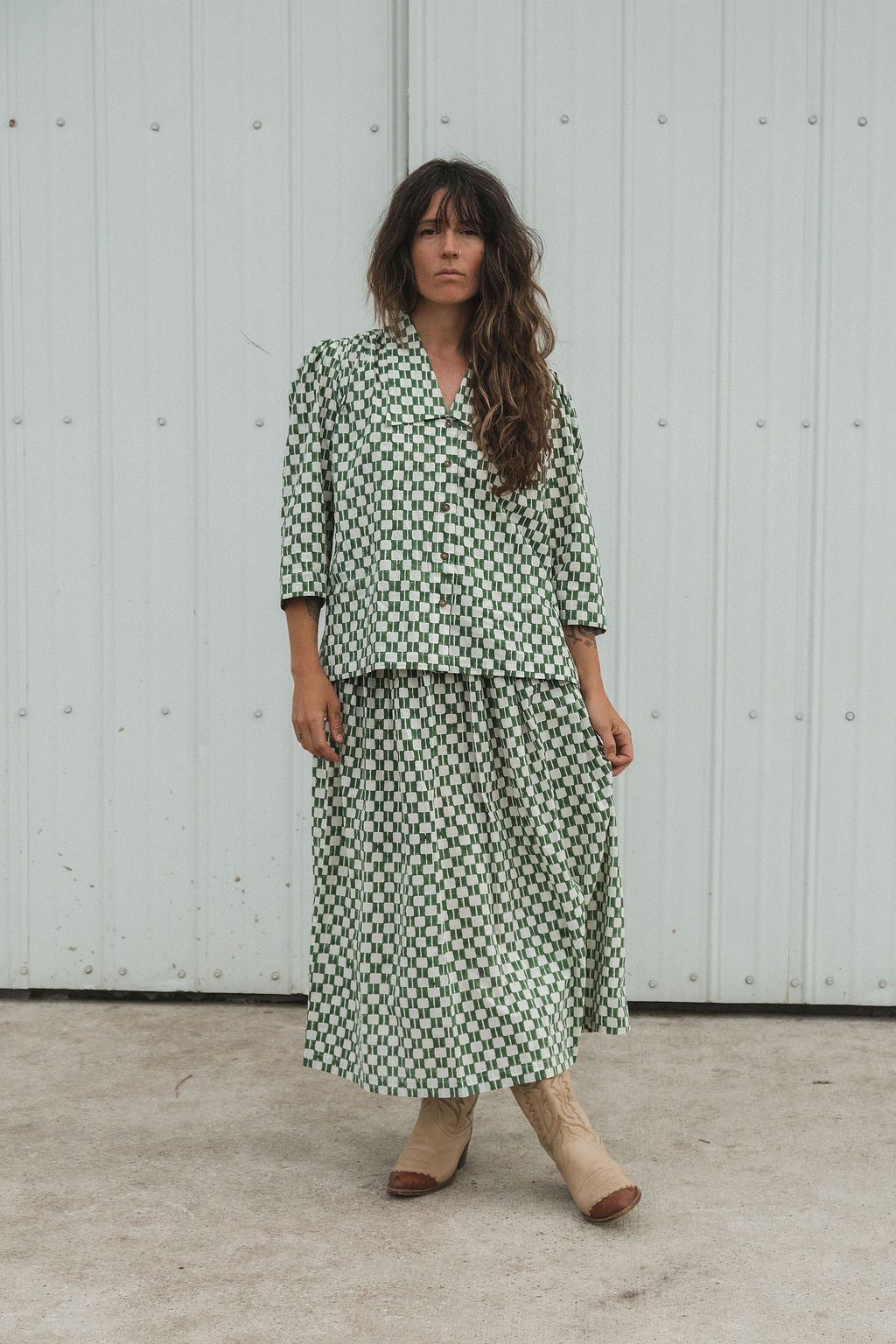 Green and white hand block-printed top made from 100% organic cotton, featuring a front button opening and a soft, breathable feel. Crafted using azo-free dyes and ethically produced, this lightweight, non-stretchy top falls 25” from the shoulder and offers a true-to-size fit. Each garment is uniquely one-of-a-kind, with natural variations in print and color that reflect its handcrafted origin—perfect for sustainable, everyday wear.