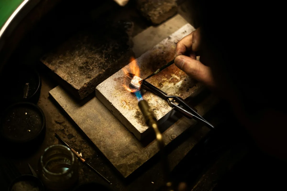 A jeweller soldering at a workbench
