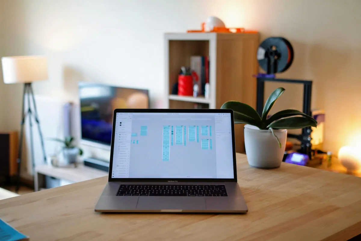 A laptop on a desk in a warm-lit room