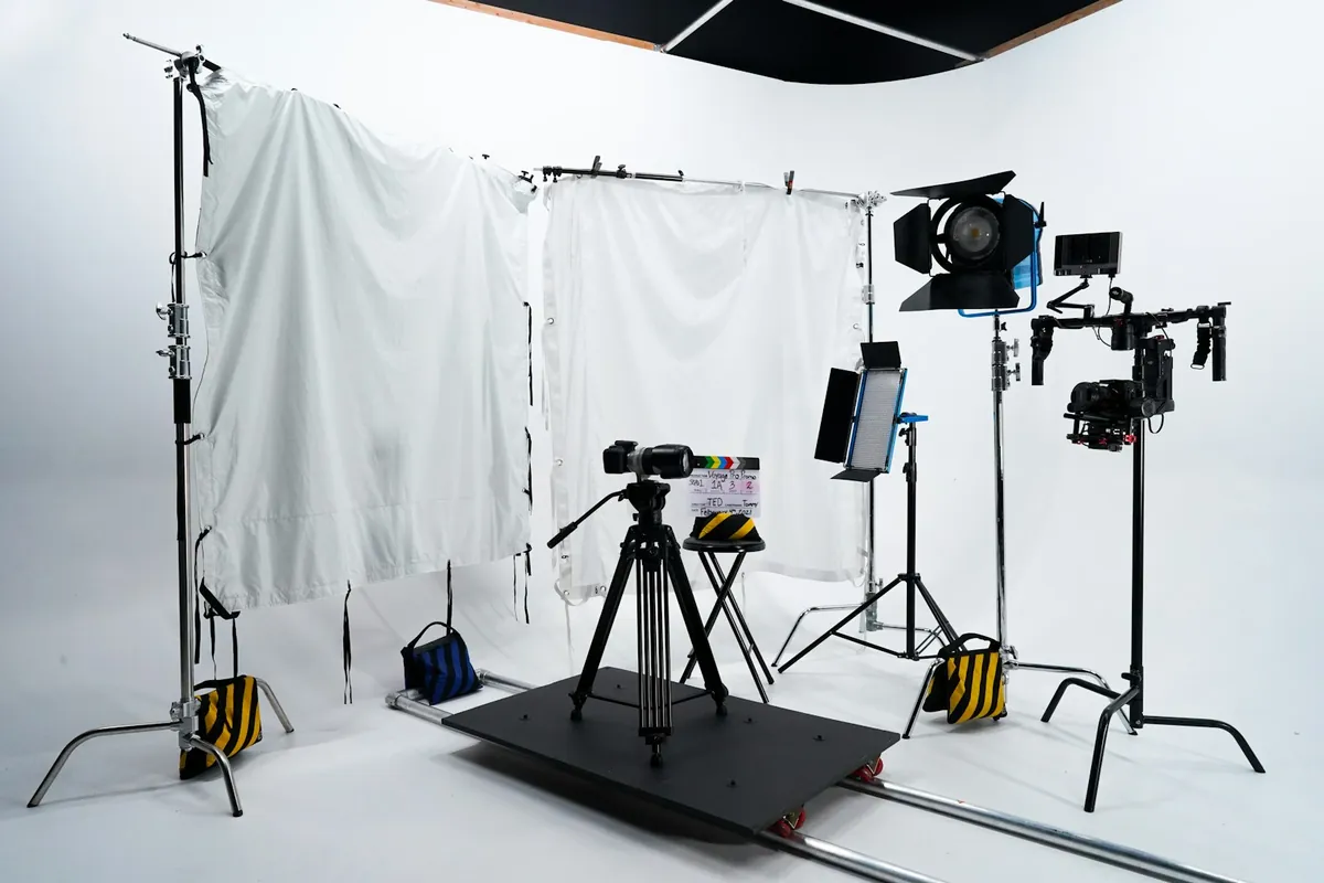 A photography studio with lights and a white backdrop
