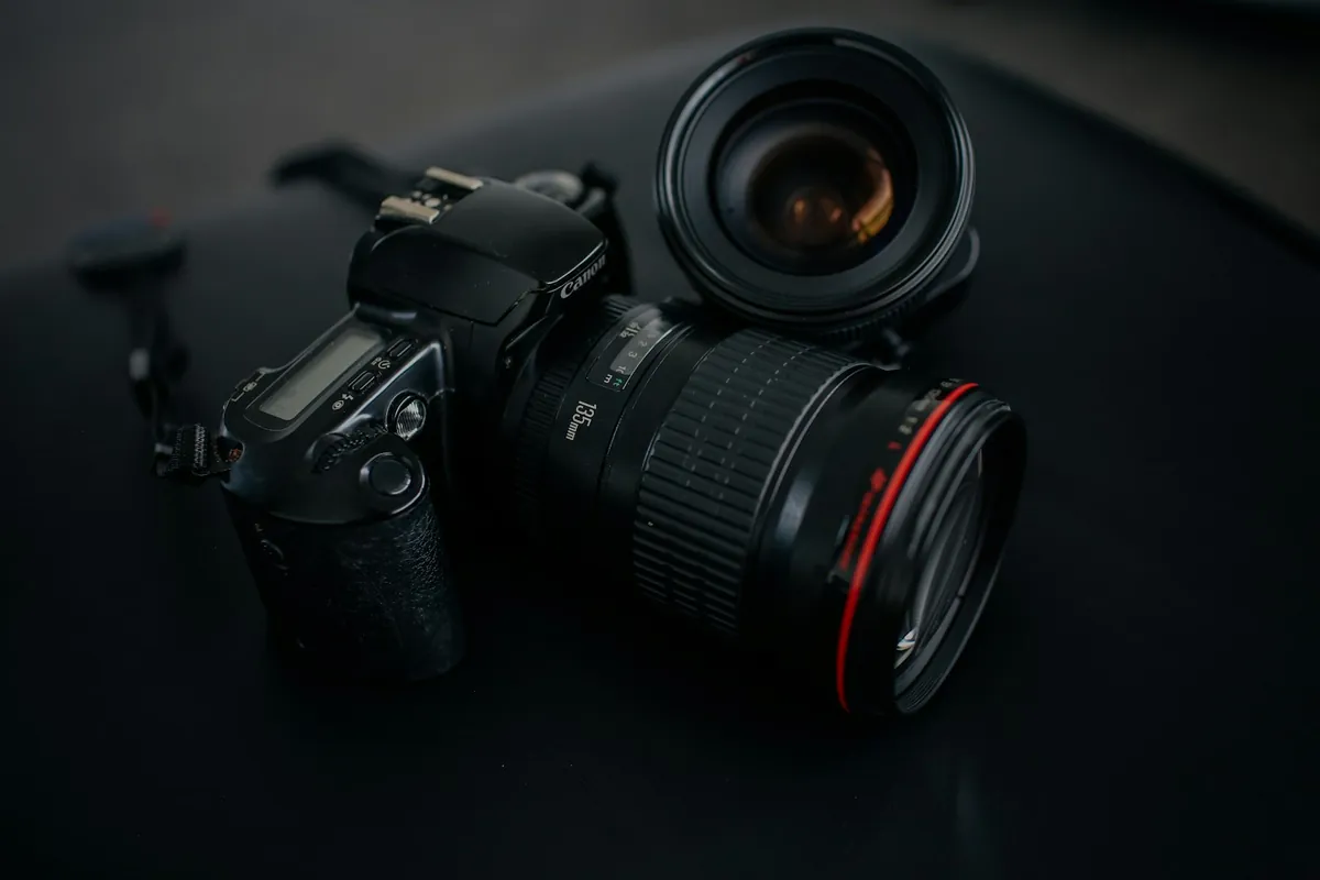 A camera and lenses on a dark table