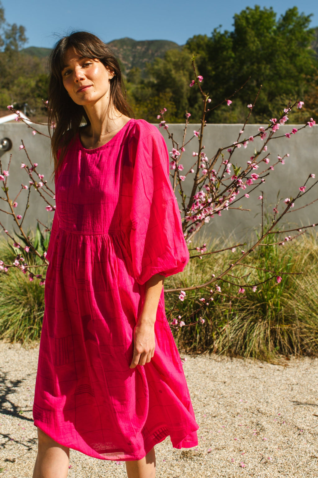 This Get Away Dress is made in a collaboration between Erica Kim @ahistoryofarchitecture and World of Crow, the dress has a scoop neck, barbie pink color, light checks in jamdani fabric