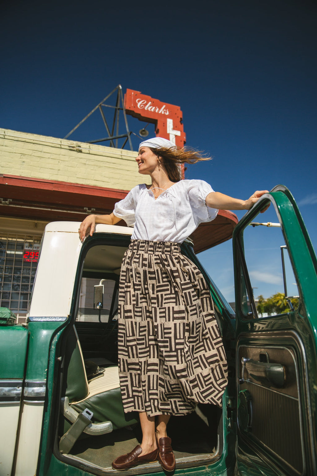 High-waisted, full-length skirt with a gathered waist and an abstract geometric print in black and beige. The voluminous silhouette and structured pleats add movement and a vintage-inspired charm, making it a statement piece with a bohemian flair.