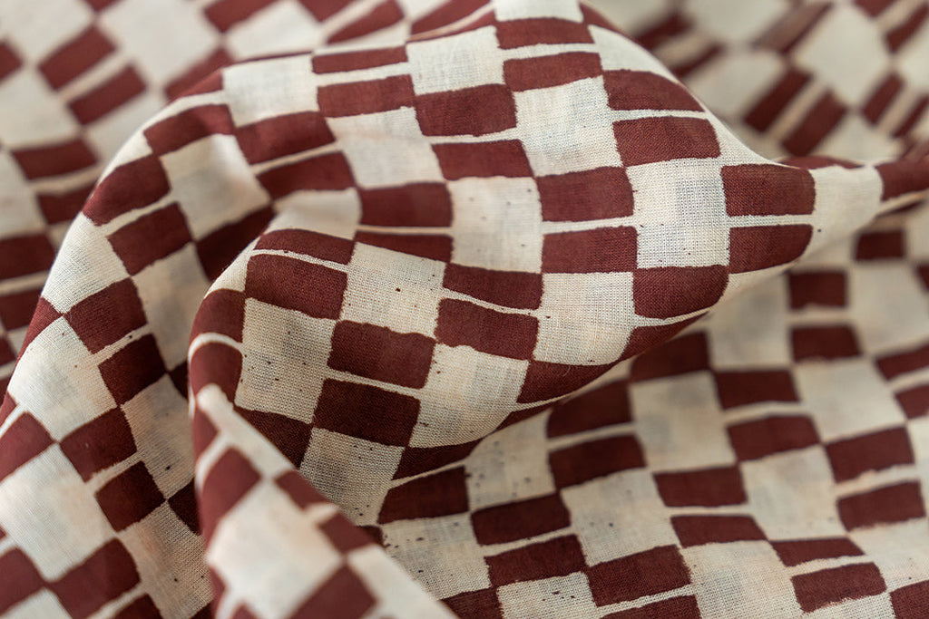 The hand block print of the artist smock, colored in the shade of brown.