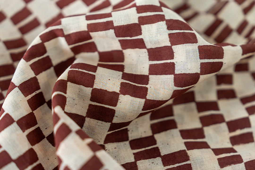 The hand block print of the artist smock, colored in the shade of brown.