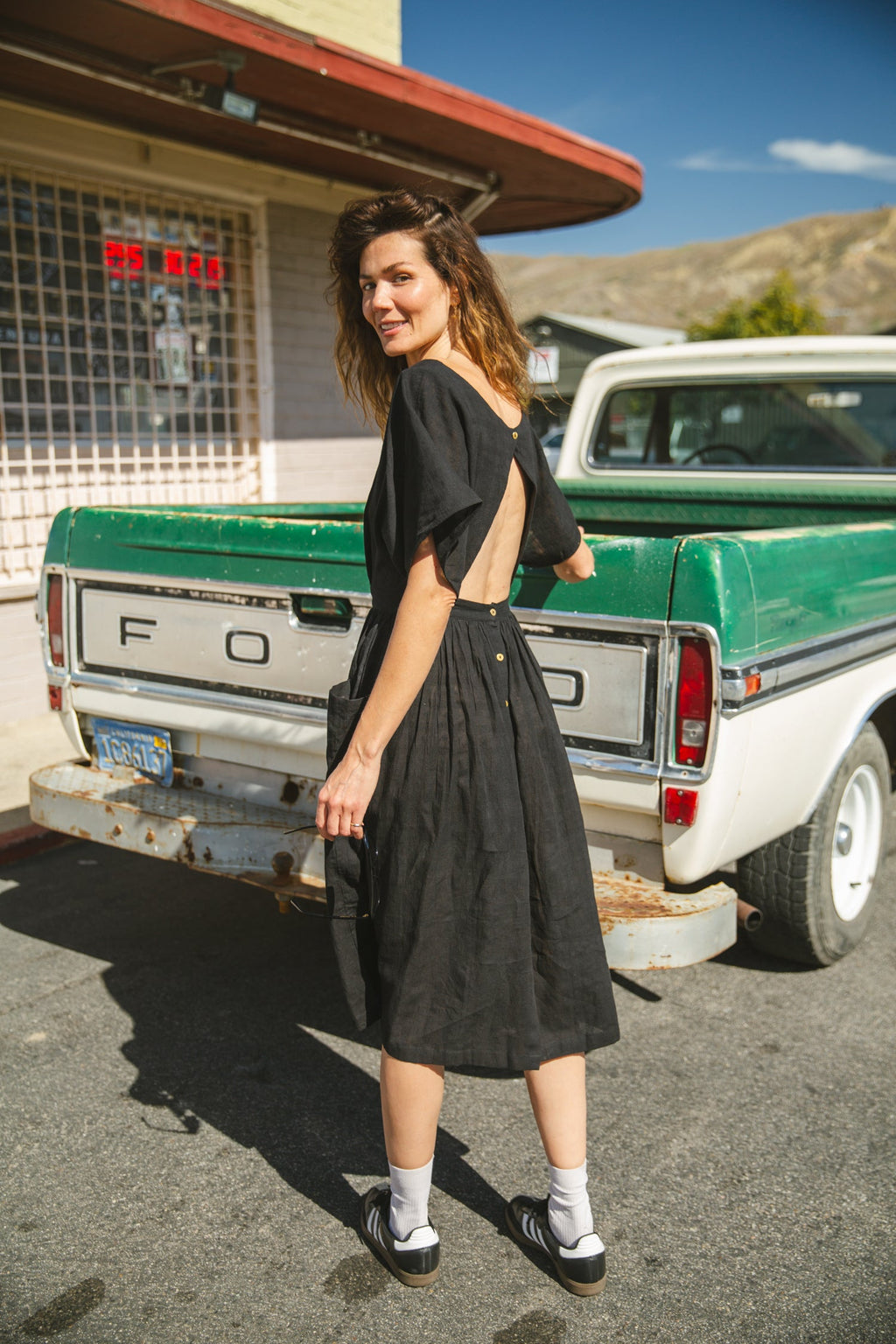 Black jamdani fabric dress with a soft, breathable texture, featuring a fitted bodice, cinched waist, and a flowy midi skirt for an effortlessly elegant and timeless silhouette.