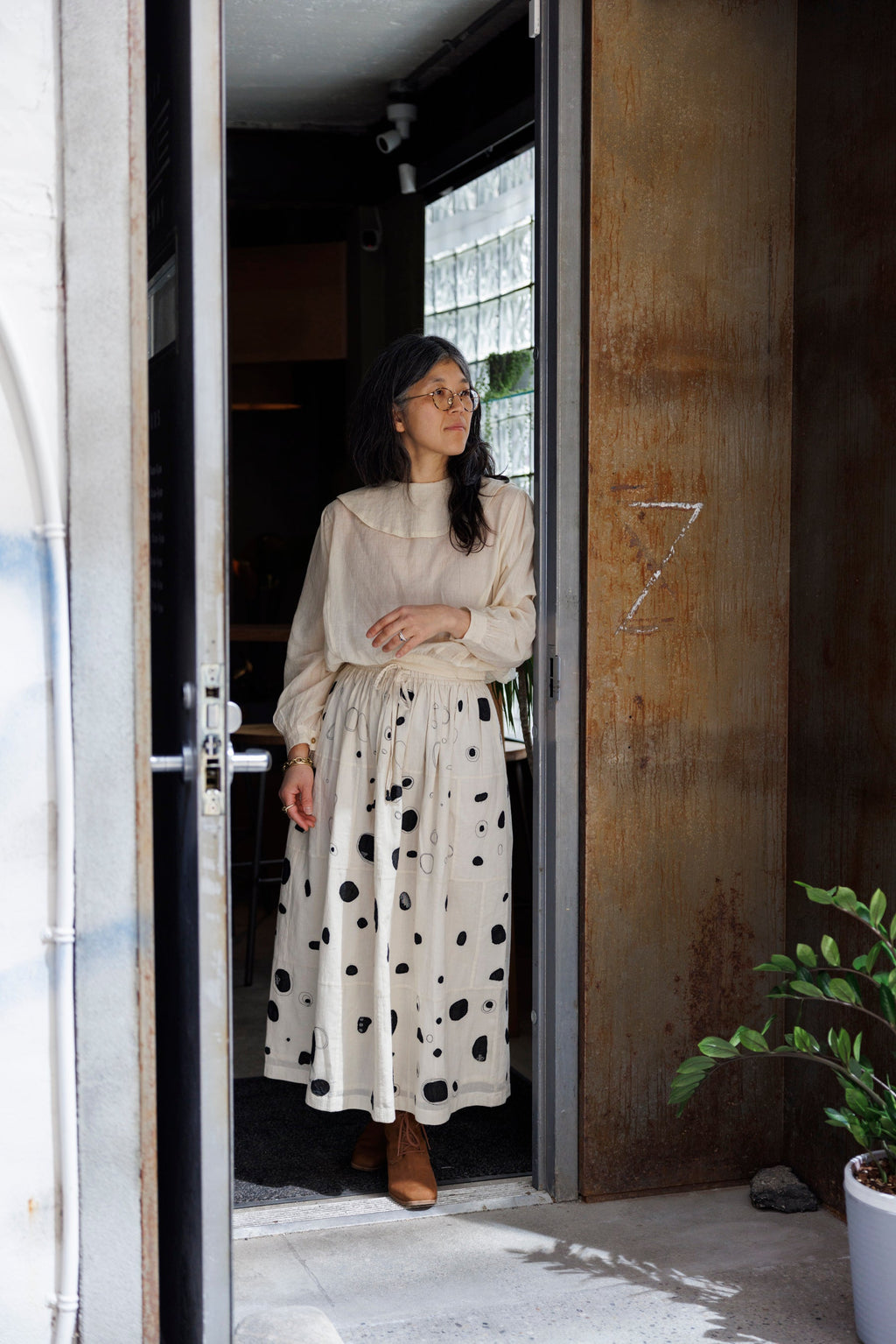 This Raindrops skirt is meticulously crafted from hand-woven fabric. Its exquisite appliqué work adds a touch of enchantment, elevating any ensemble. With its timeless black and white palette, this skirt effortlessly complements a variety of tops and shirts, ensuring versatility and sophistication with every wear.