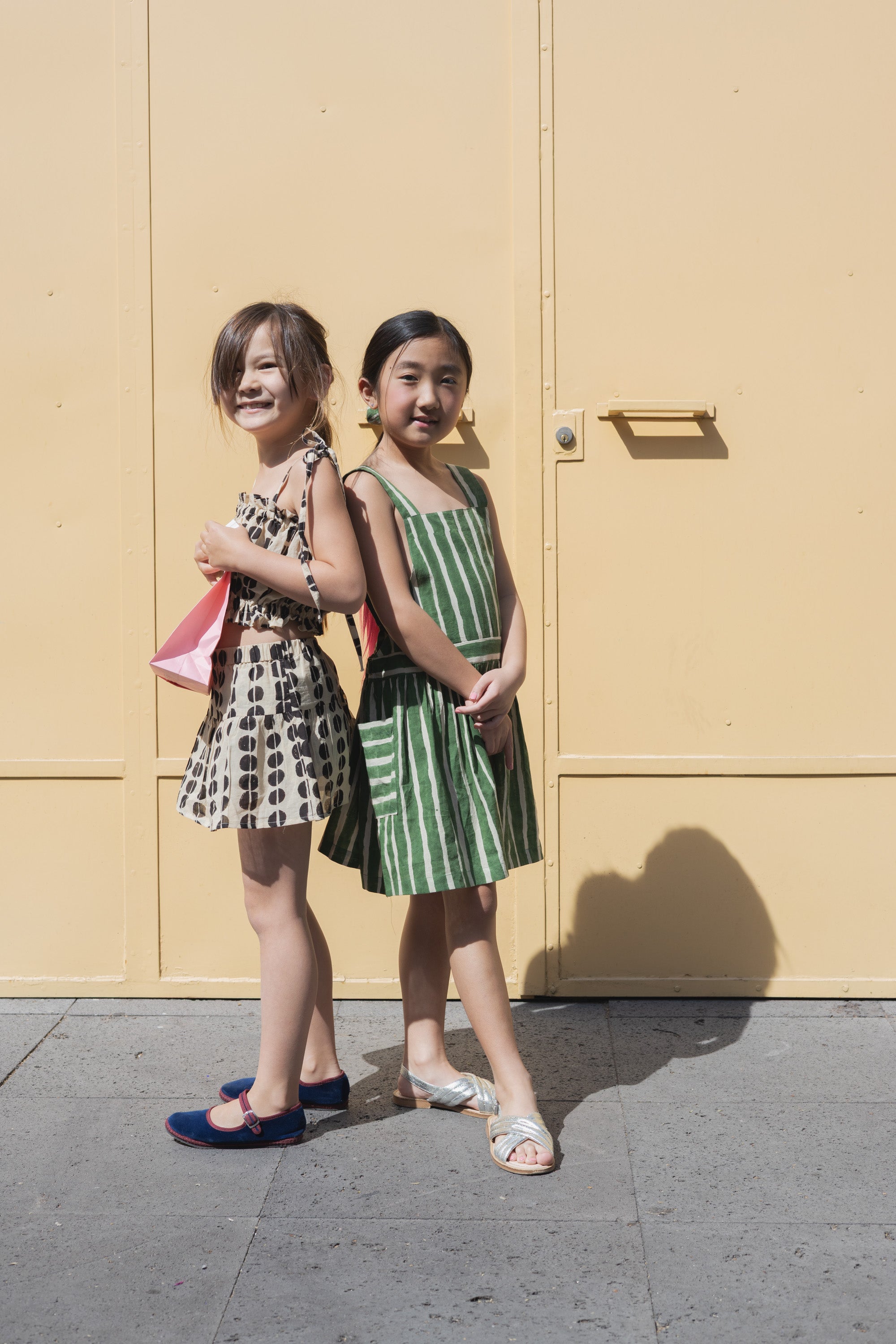 Green and white striped sleeveless dress with a halter neckline, gathered waist, and a relaxed fit.