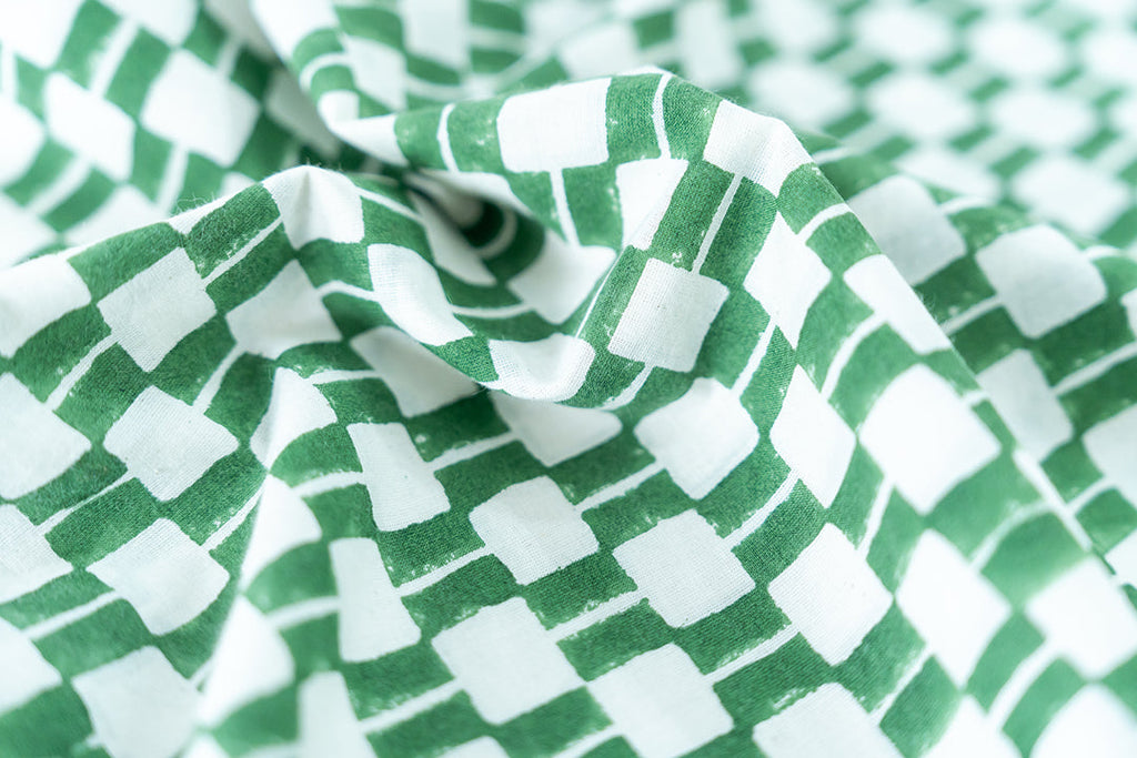 Detailed view of hand block printed fabric in green and white hue.