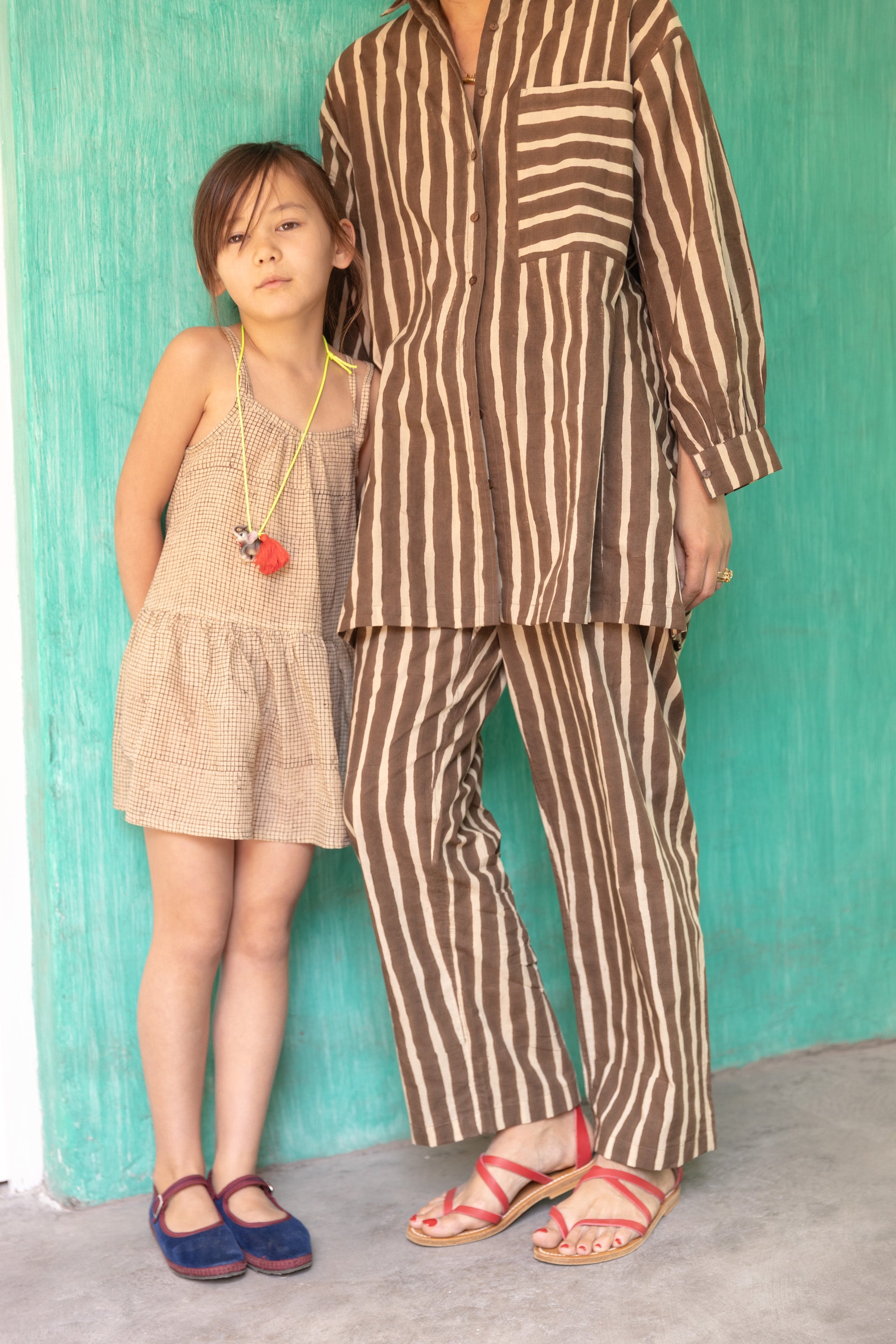 Honey-checked sleeveless frock with a ruched bodice, thin shoulder straps, and a tiered, flared skirt for a breezy, playful look.