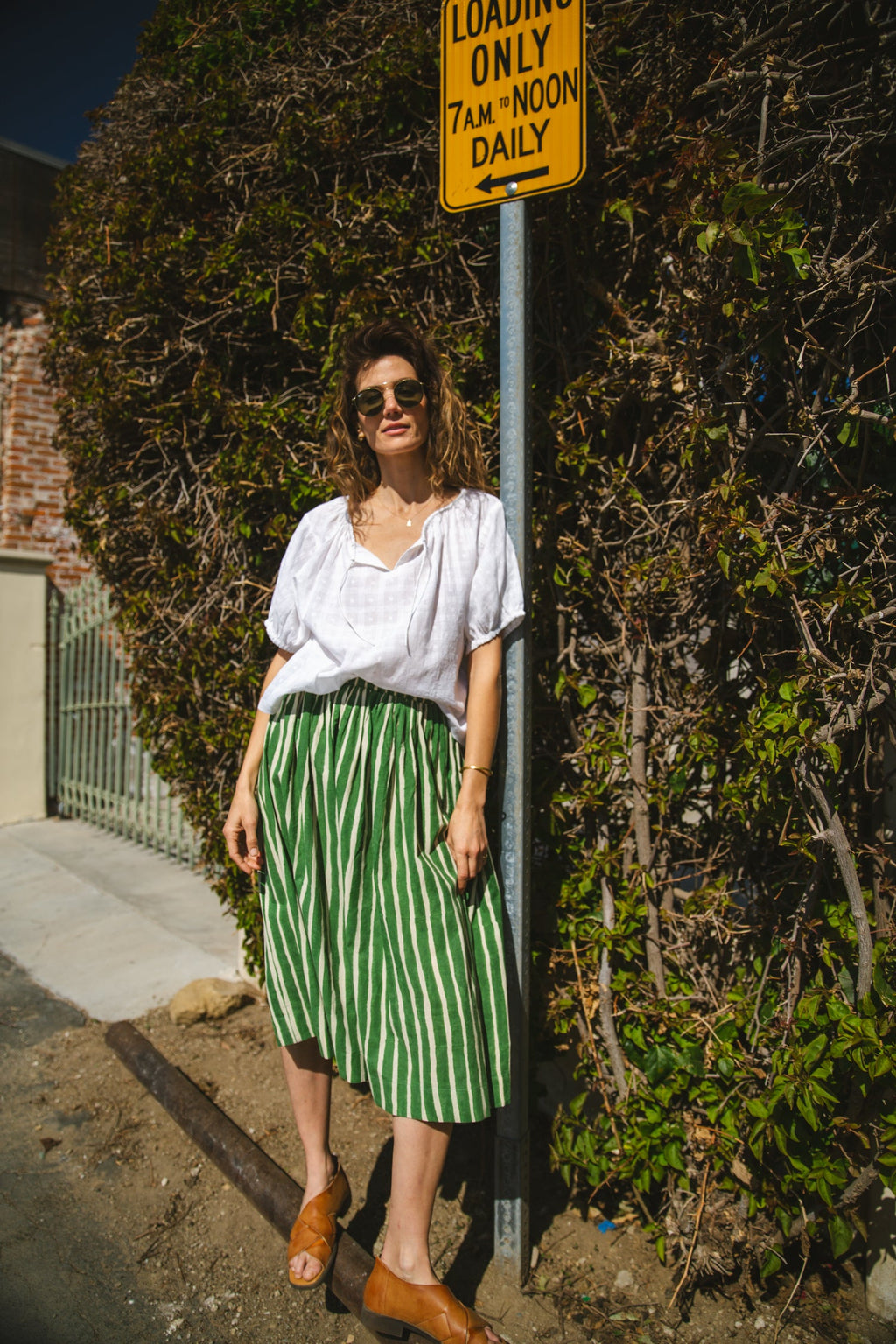 Green and white striped midi skirt with an elastic waistband, lightweight breathable fabric, and a gathered silhouette for a relaxed and stylish look.