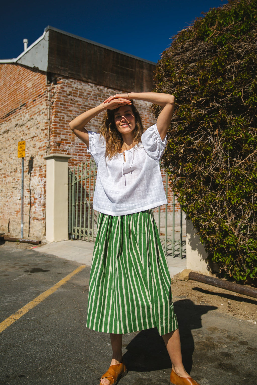 Green and white striped midi skirt with an elastic waistband, lightweight breathable fabric, and a gathered silhouette for a relaxed and stylish look.