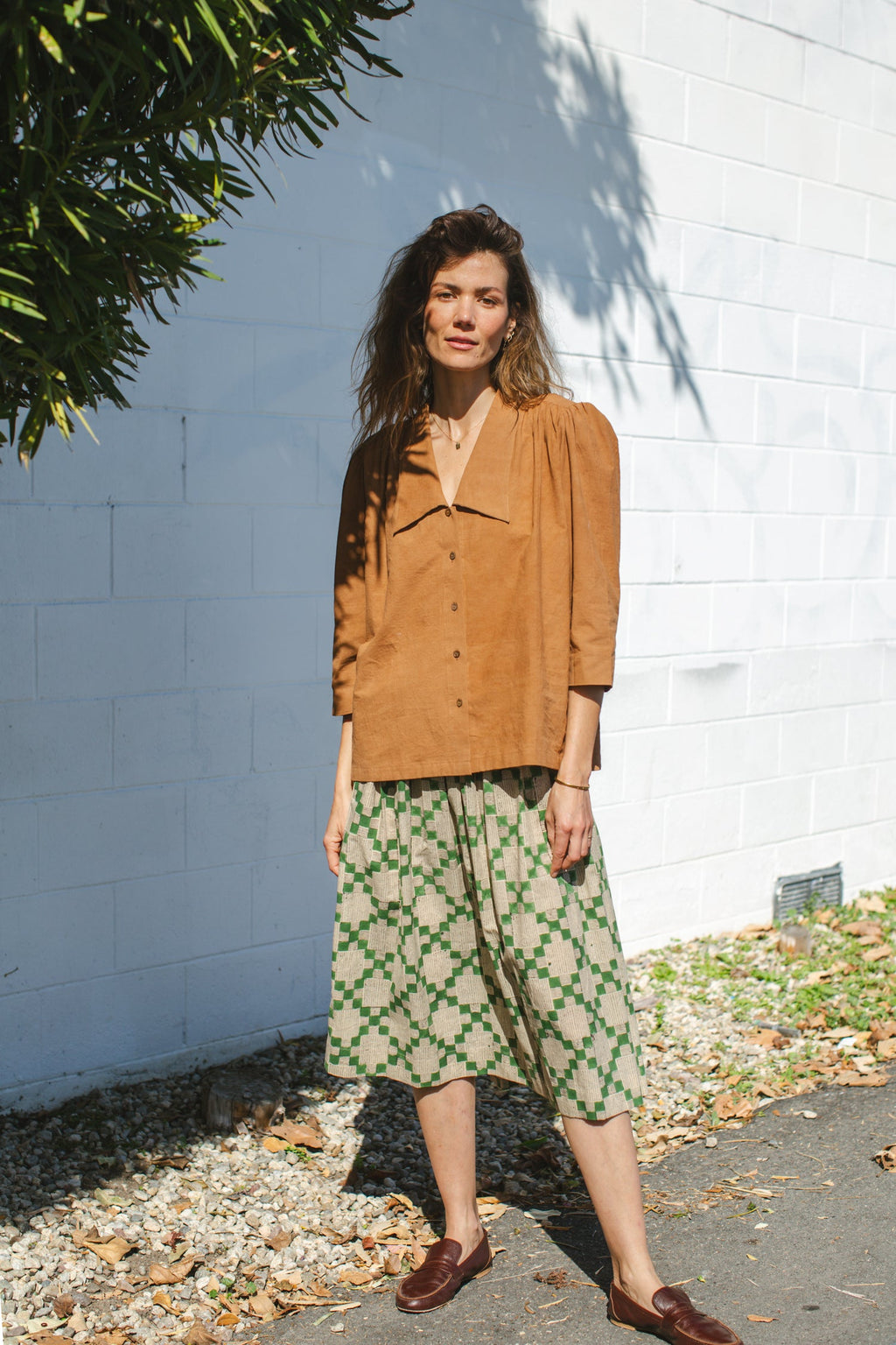 Green and beige printed midi skirt with an elastic waistband, featuring a geometric pattern, lightweight fabric, and a flowy silhouette for a comfortable and stylish look.