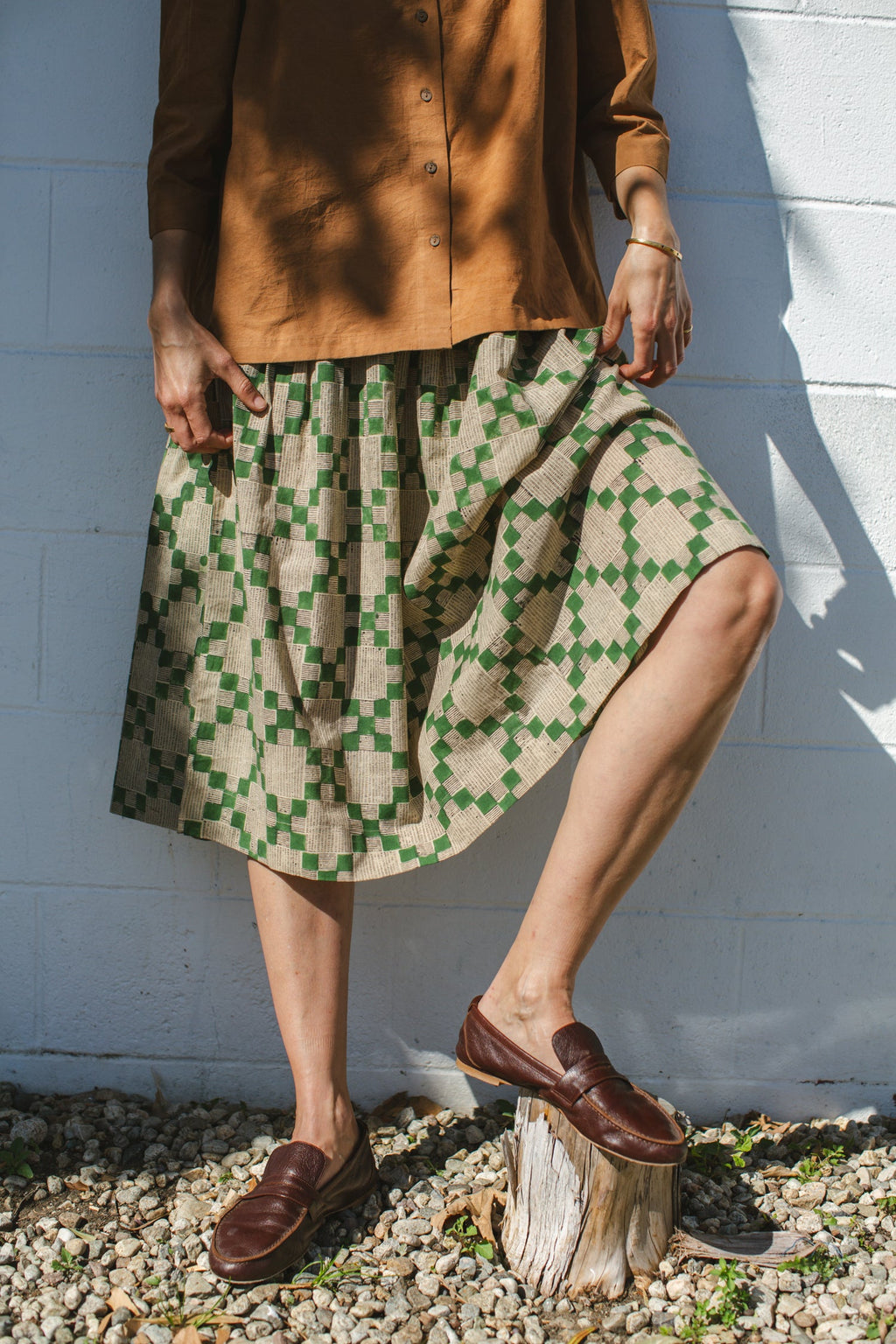 Green and beige printed midi skirt with an elastic waistband, featuring a geometric pattern, lightweight fabric, and a flowy silhouette for a comfortable and stylish look.