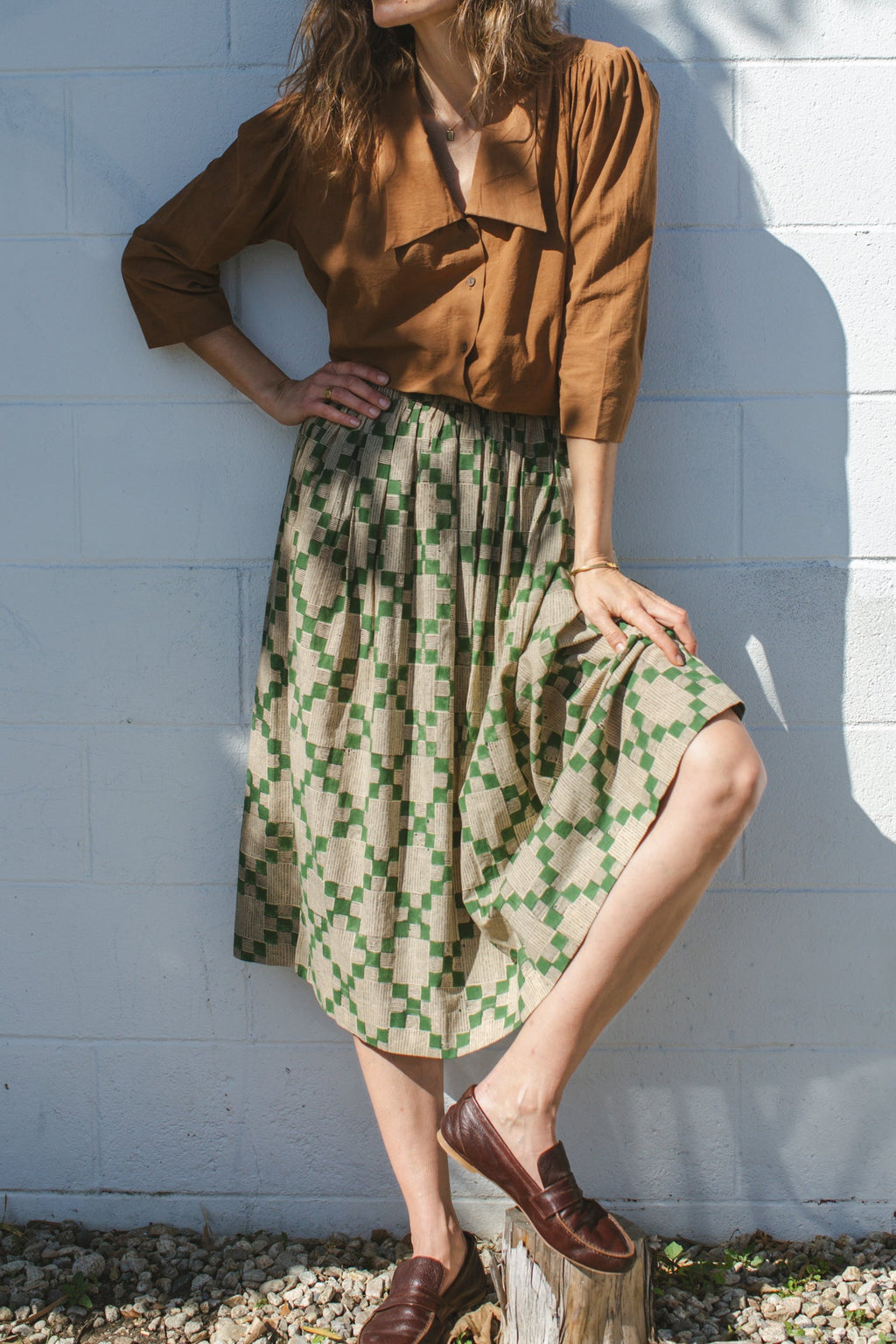 Green and beige printed midi skirt with an elastic waistband, featuring a geometric pattern, lightweight fabric, and a flowy silhouette for a comfortable and stylish look.