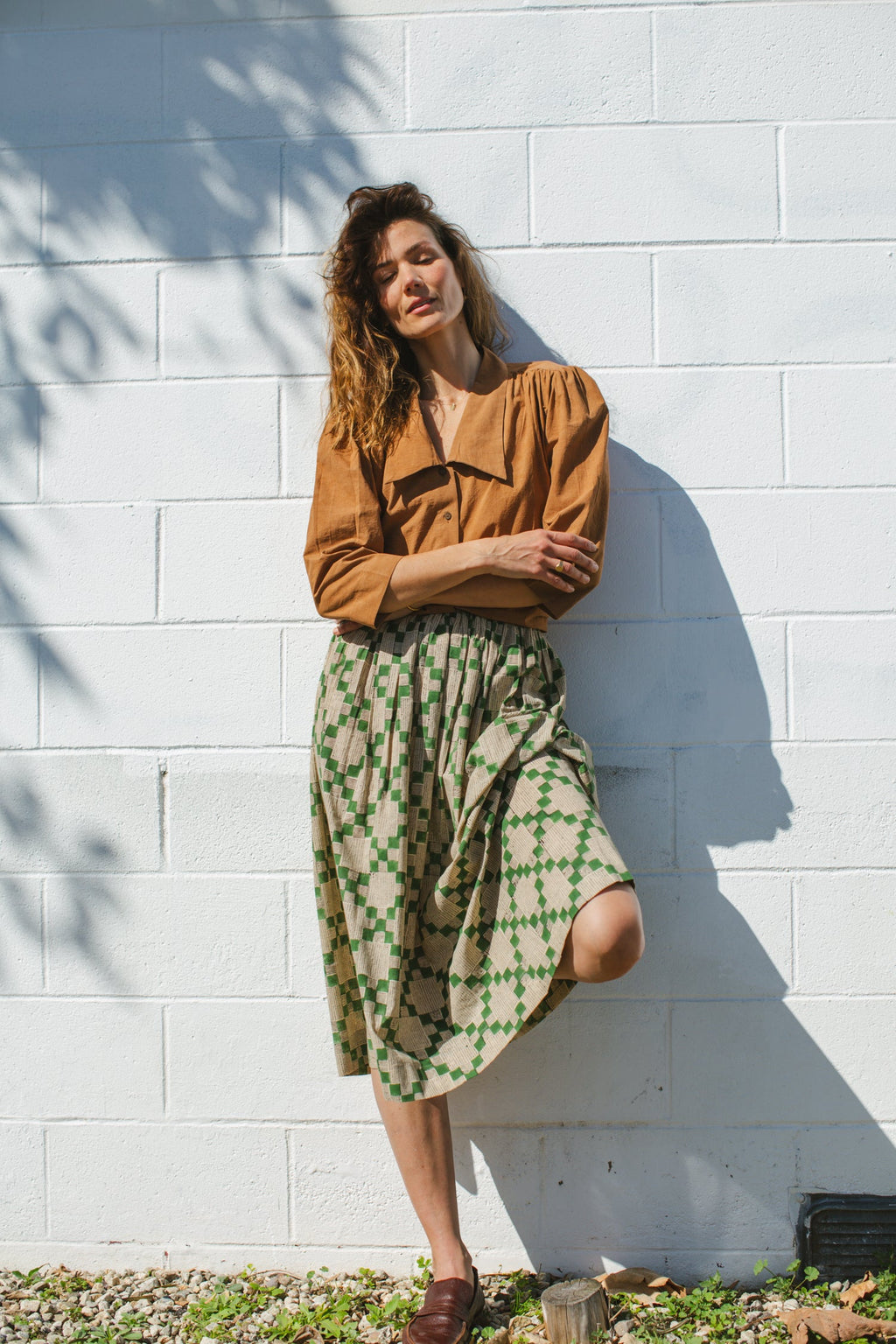 Green and beige printed midi skirt with an elastic waistband, featuring a geometric pattern, lightweight fabric, and a flowy silhouette for a comfortable and stylish look.