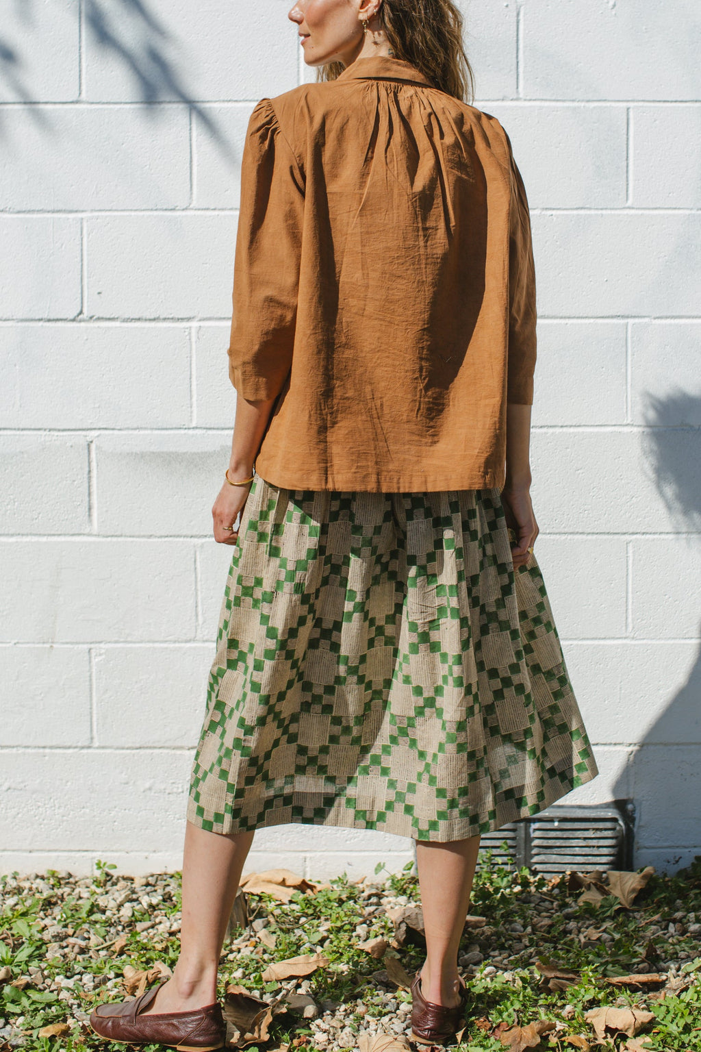 Green and beige printed midi skirt with an elastic waistband, featuring a geometric pattern, lightweight fabric, and a flowy silhouette for a comfortable and stylish look.