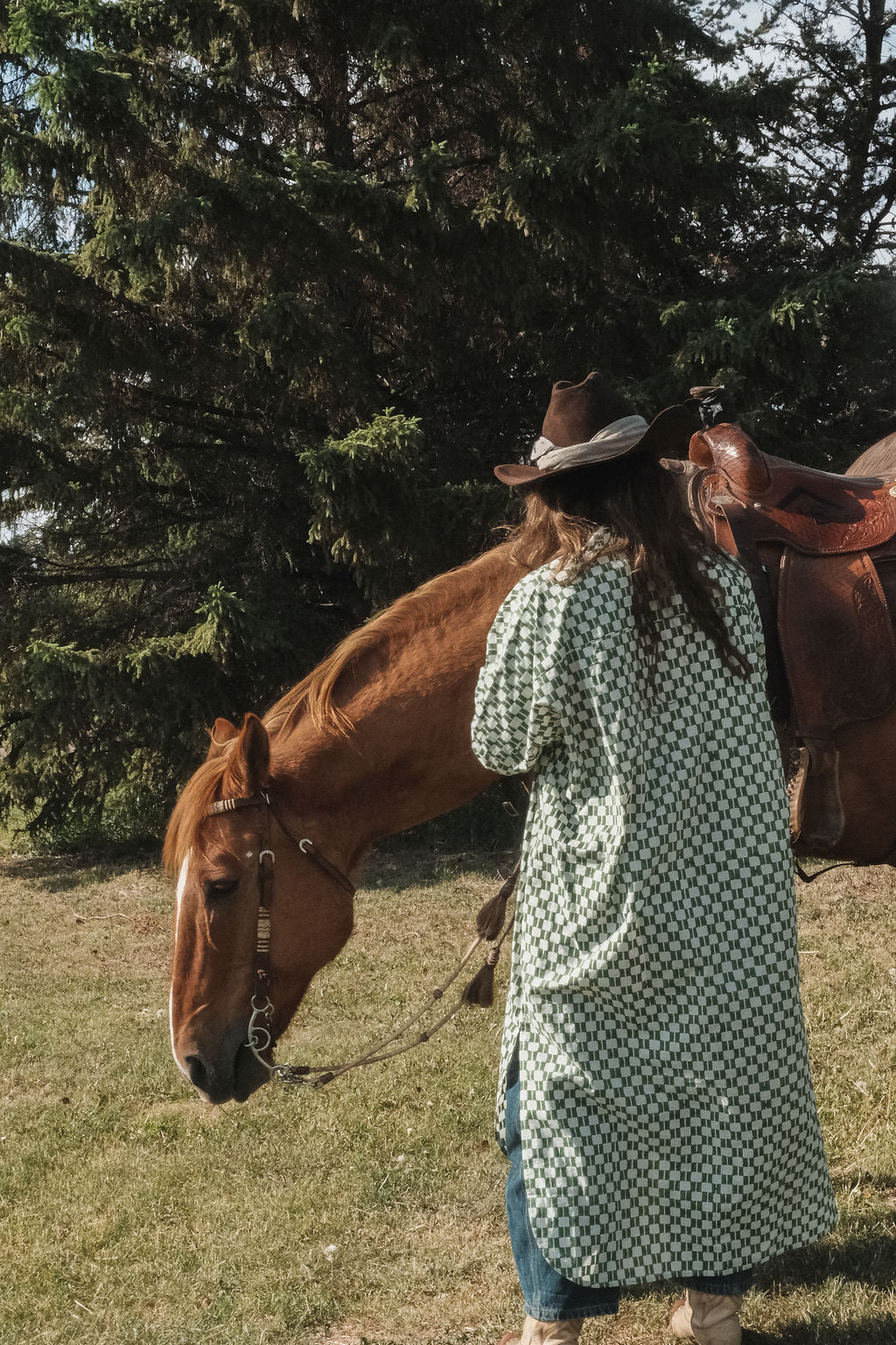 Green and white hand block-printed dress made from 100% organic cotton, featuring a front button opening and high-low hemline. Crafted over 5 days using azo-free dyes, the lightweight, non-stretchy fabric feels soft and breathable on the skin. Each piece is ethically made and uniquely one-of-a-kind, with subtle variations in print and color that highlight its artisanal nature. Falls 42” from the shoulder, offering a relaxed silhouette that fits true to size.