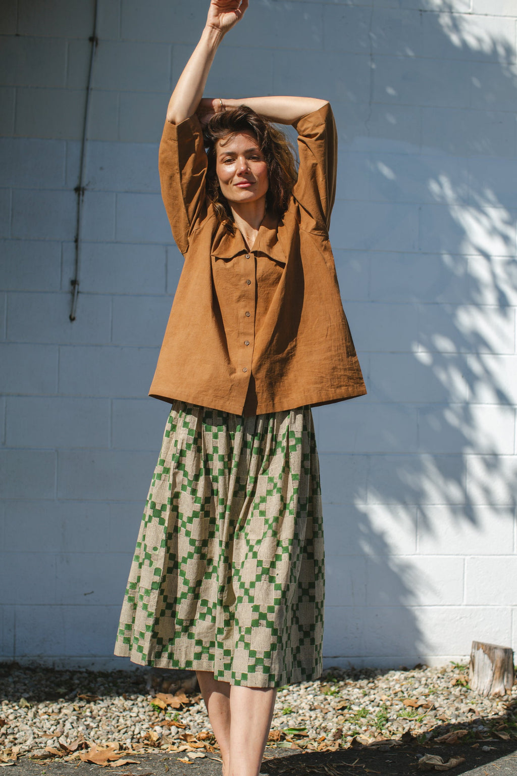 Vintage-inspired brown suede blouse with a wide-notch collar and gathered shoulders, adding a touch of retro elegance. The earthy caramel hue enhances its timeless appeal, making it a versatile statement piece.