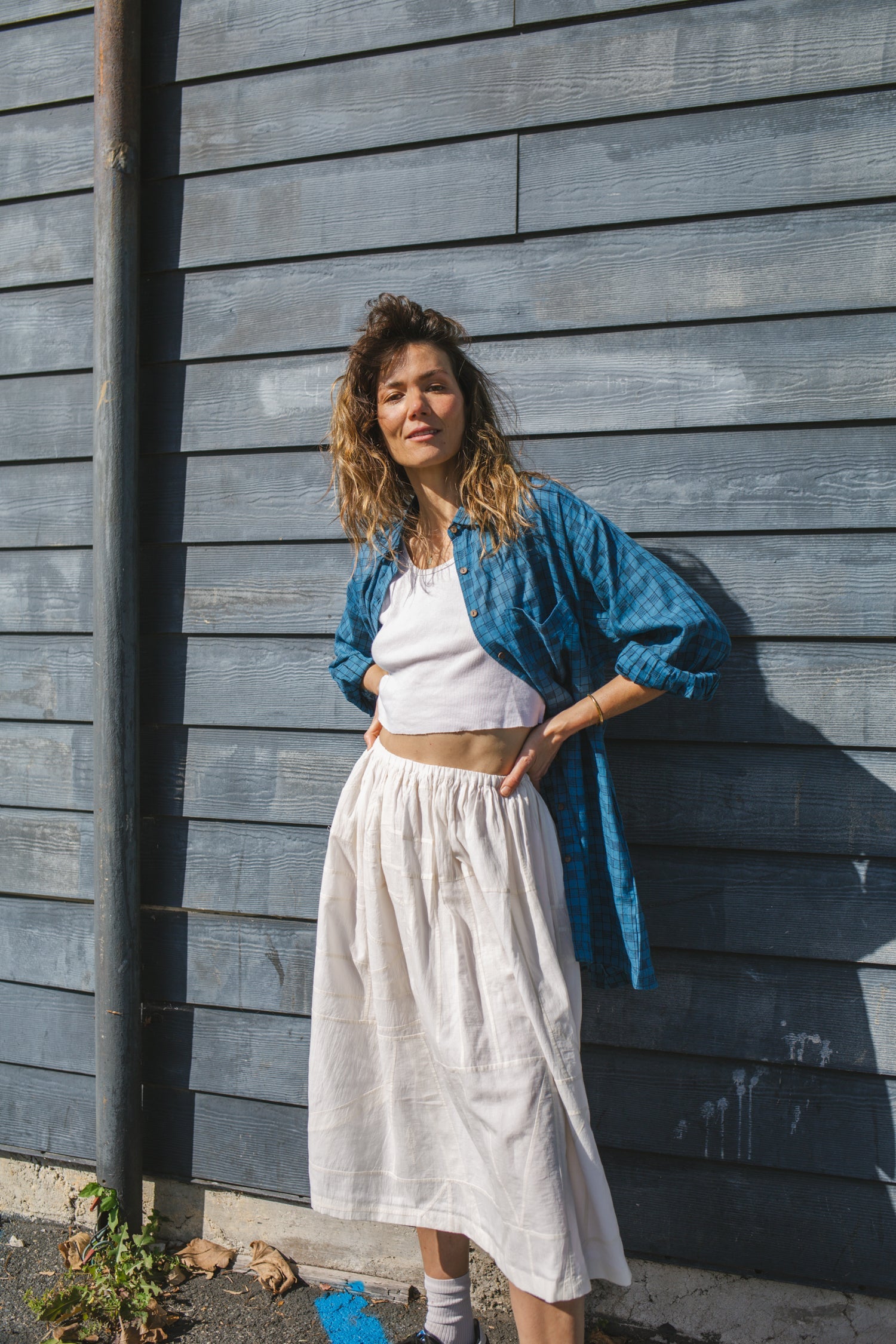 White flowy midi skirt with subtle plaid pattern, lightweight fabric, and gathered waist for an elegant and casual look.