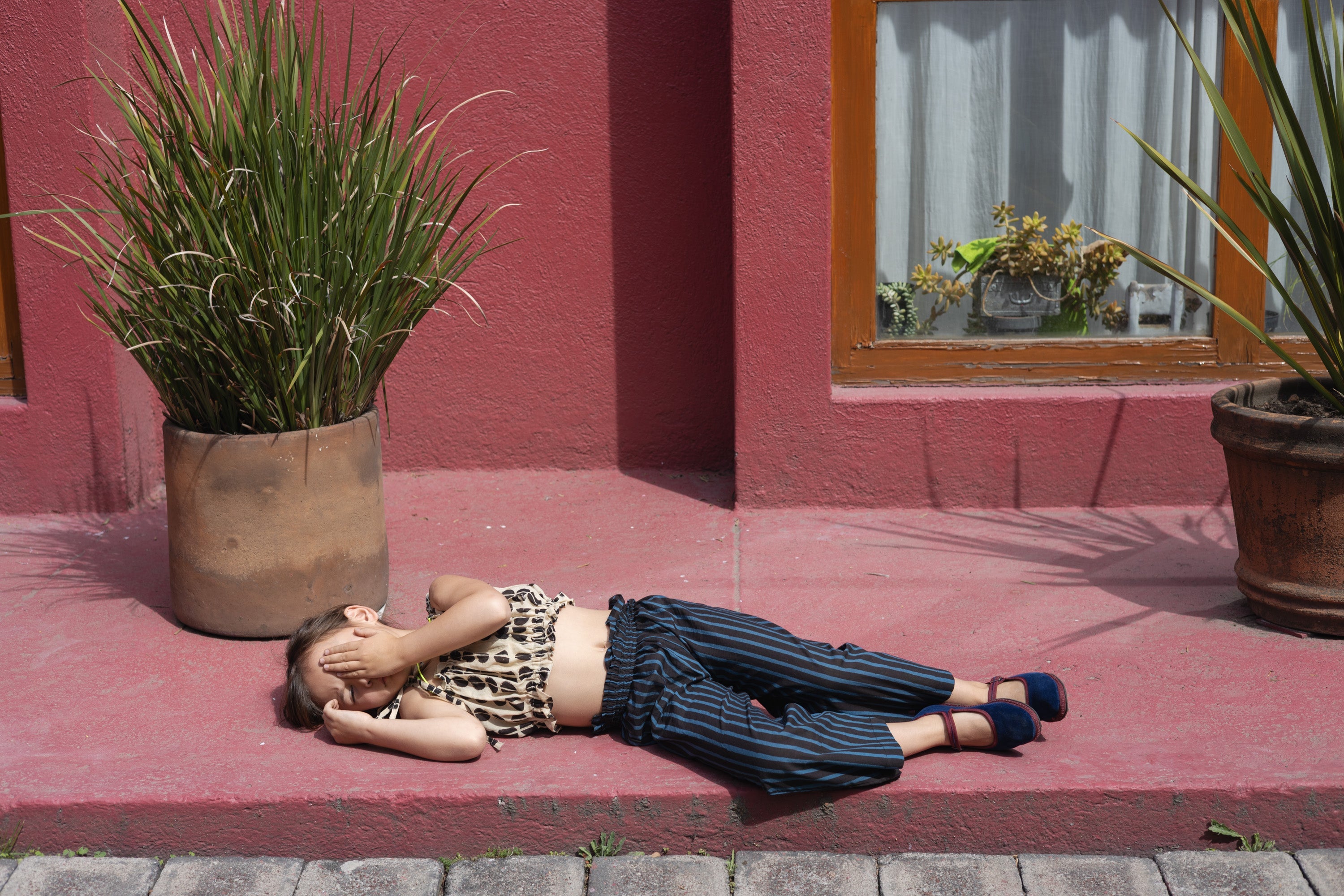 A pair of kids' wide-leg pants featuring vertical blue and black stripes. The pants have a high, elasticated waistband for a comfortable fit and a slightly cropped length, adding a relaxed and playful touch to the outfit.