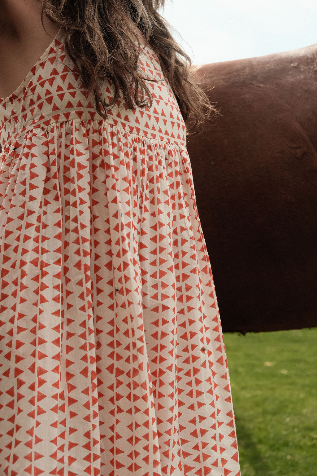This is dress is the quintessential example of a sundress - perfect for get-outs and adventures. The flowy garment is made with azo free dye with tiny red triangle on a white base. Each triangle being unique as printed by a hand block. 