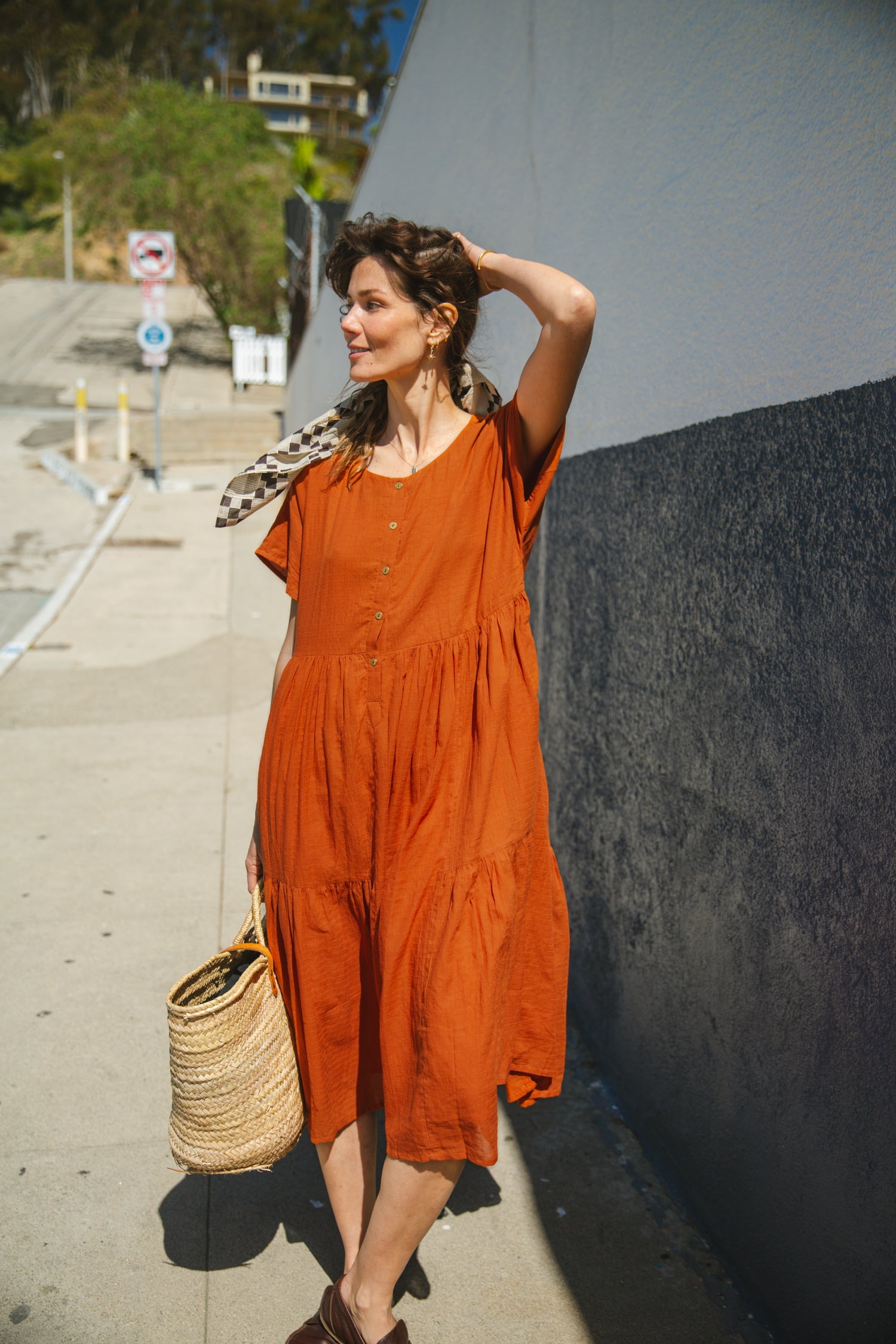 Rust orange tiered midi dress with a relaxed fit, short sleeves, a round neckline with a buttoned placket, and soft, lightweight fabric for an effortless, breezy style.