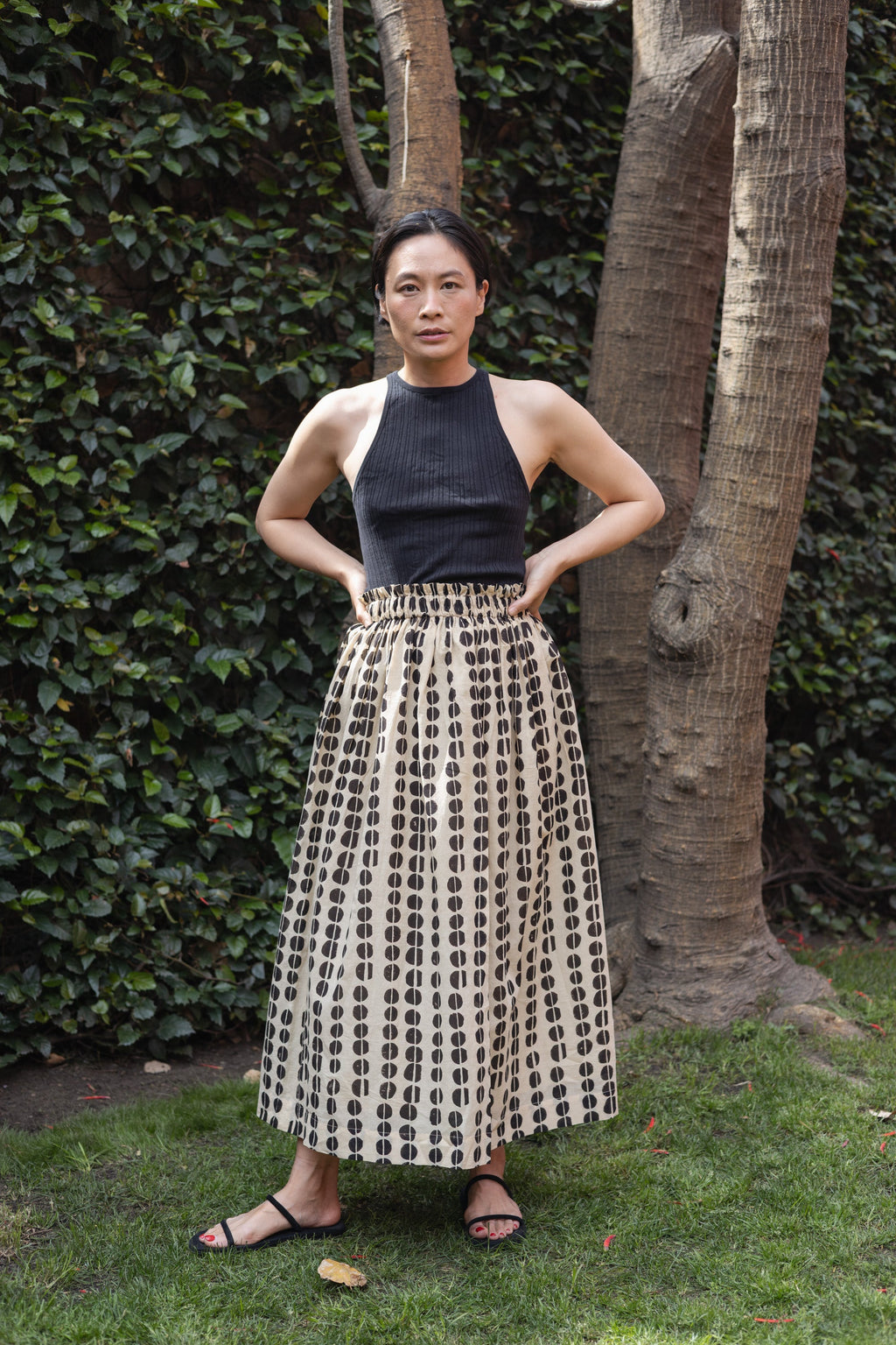 A lightweight, flowing midi skirt crafted from soft, breathable fabric. The design features a hand-blocked polka dot print in an organic, artisanal pattern, adding a unique touch to the neutral base. The elasticated waistband offers comfort and a flexible fit for its effortless, relaxed feel.