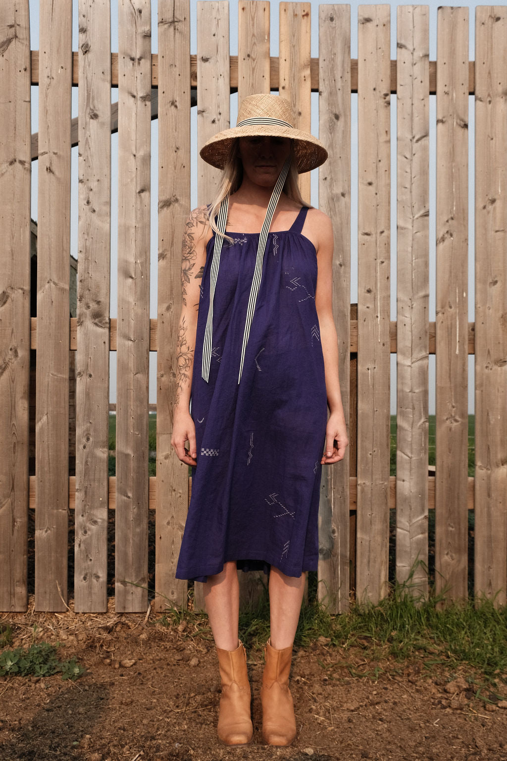 Long indigo blue Jamdani dress featuring wide straps, a gathered neckline, and subtle white abstract geometric motifs. Handwoven from soft, lightweight cotton and dyed with azo-free dyes, this fully lined dress is crafted over 7 days using traditional weaving techniques. Ethically made with a relaxed, bohemian silhouette, it's perfect for summer wear—combining artisanal charm with breathable comfort.