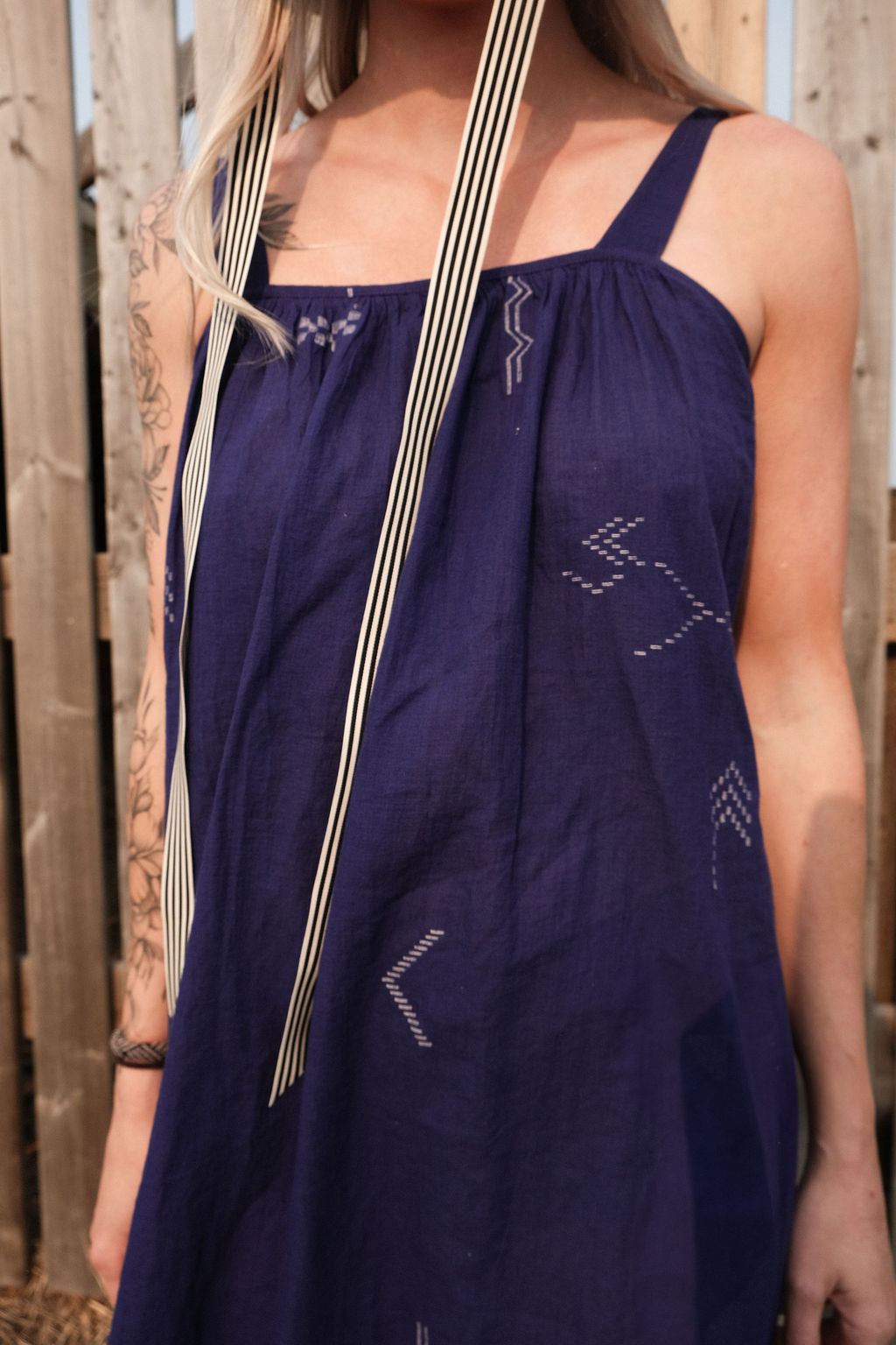Long indigo blue Jamdani dress featuring wide straps, a gathered neckline, and subtle white abstract geometric motifs. Handwoven from soft, lightweight cotton and dyed with azo-free dyes, this fully lined dress is crafted over 7 days using traditional weaving techniques. Ethically made with a relaxed, bohemian silhouette, it's perfect for summer wear—combining artisanal charm with breathable comfort.