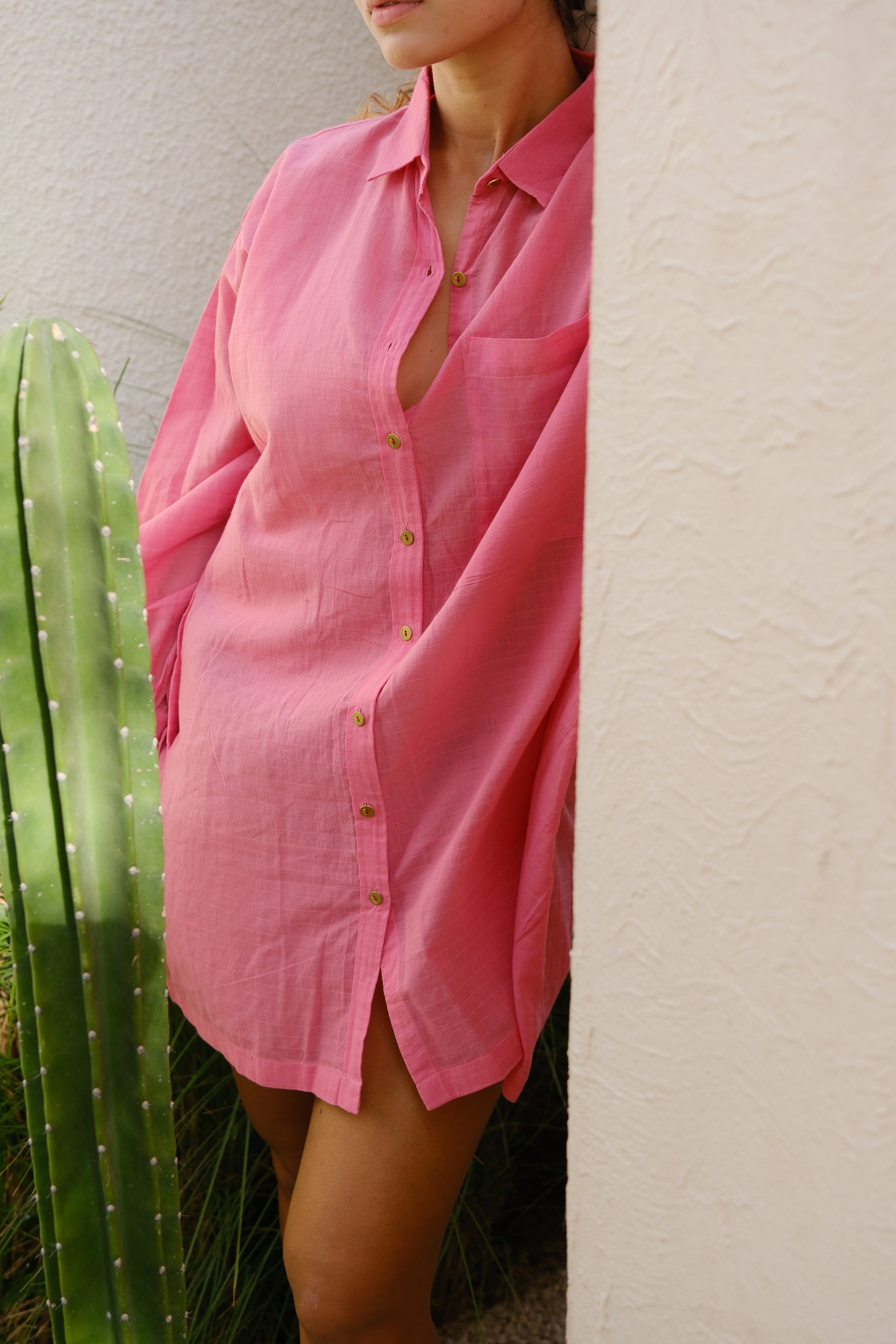 Introducing the Mosaic Pink Artist Smock, a fun and essential piece for any creator, crafted in collaboration between Audrey E Leary and World of Crow. This short, hand-woven cotton smock features a straight collar, full sleeves, and a spacious front pocket, perfect for holding tools. Designed with midweight, non-stretchy fabric, it offers a comfortable fit and is ideal for painting, crafting, and enhancing your creative projects