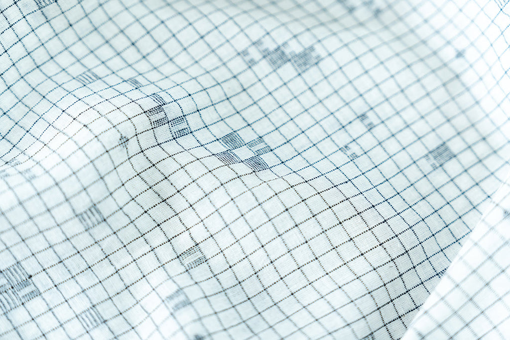 Details of the dress's fabric featuring checkered pattern with scattered motif in jamdani.